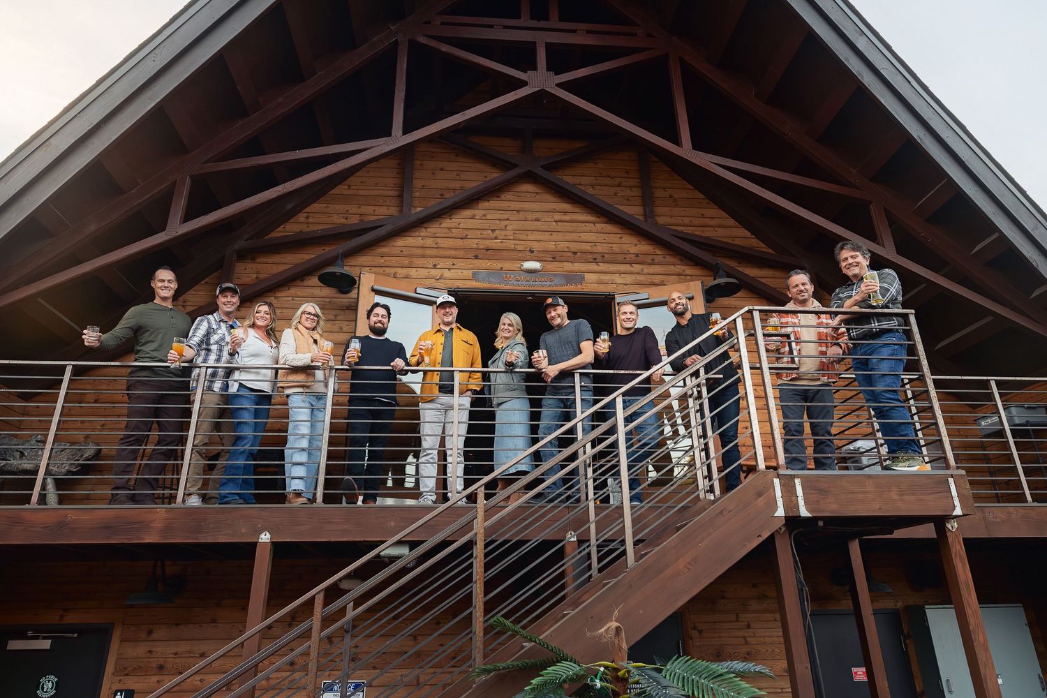 Group gathered on wooden deck balcony of rustic lodge building.