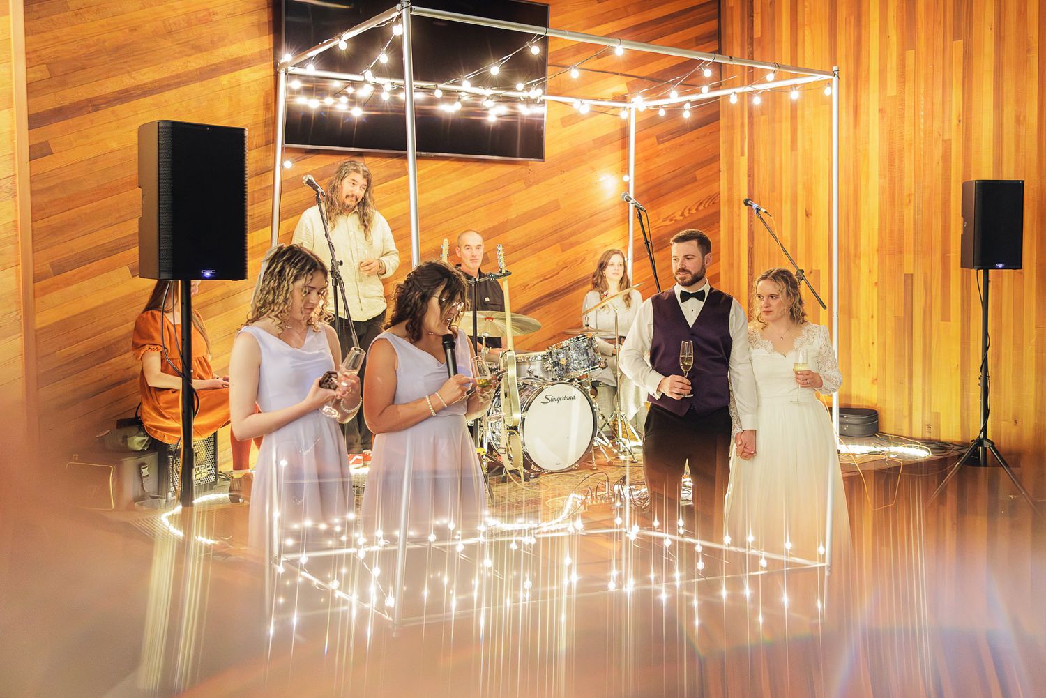Musicians performing on stage with string lights and modern decor creating an elegant atmosphere.