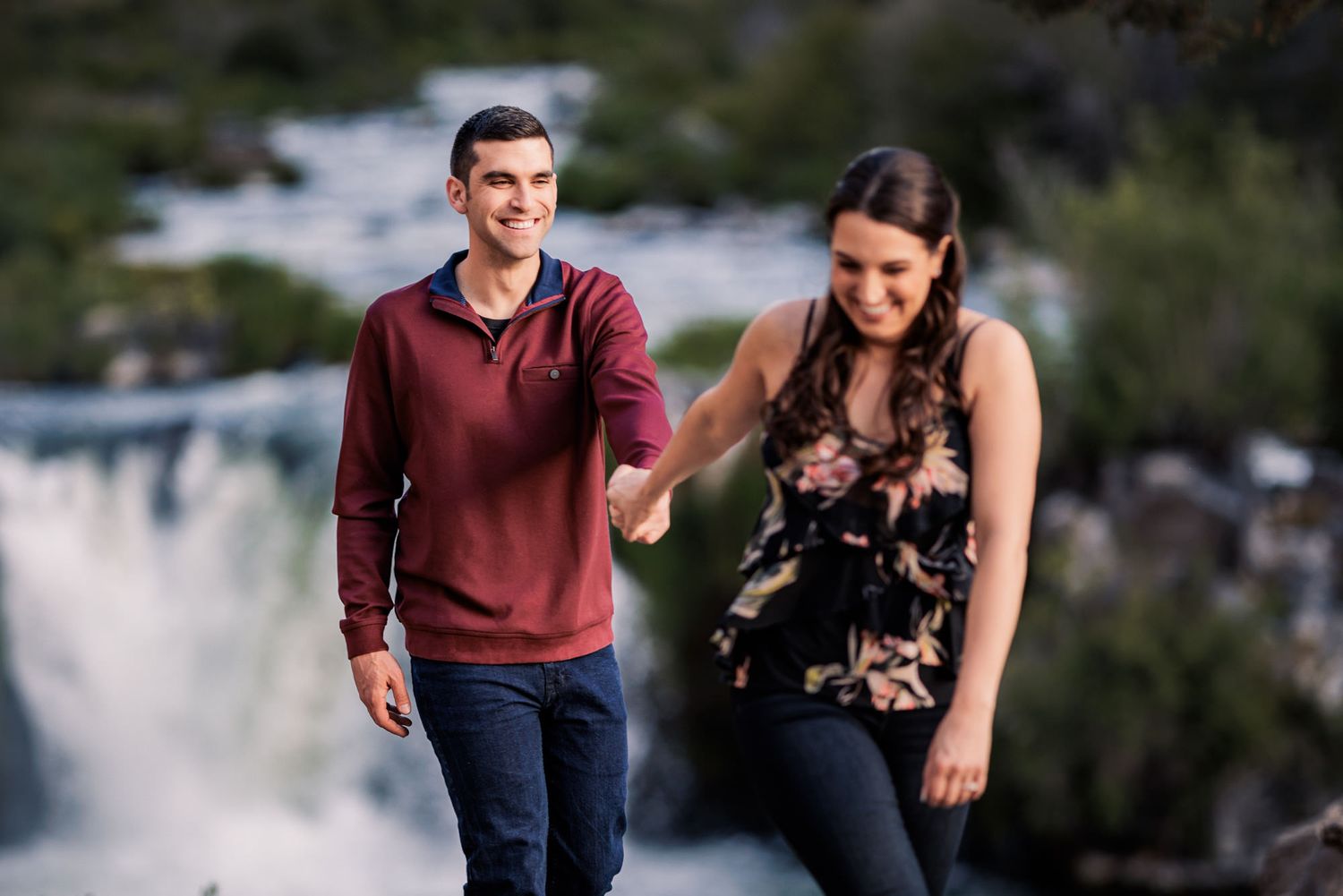 A couple runs together on a paved path through a scenic outdoor setting during a workout session.