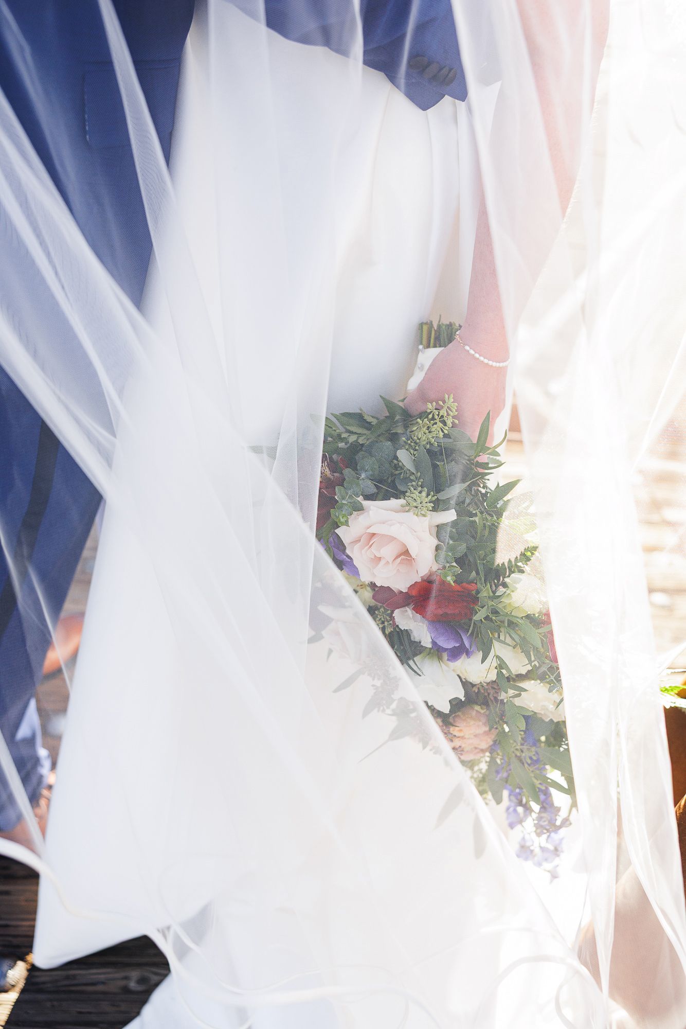 White sheer curtains and delicate floral arrangements create an ethereal wedding ceremony backdrop.