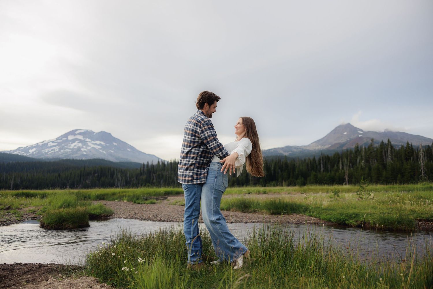 Scenic mountain vista with a couple exploring pure wilderness and snow-capped peaks in beautiful natural landscape.