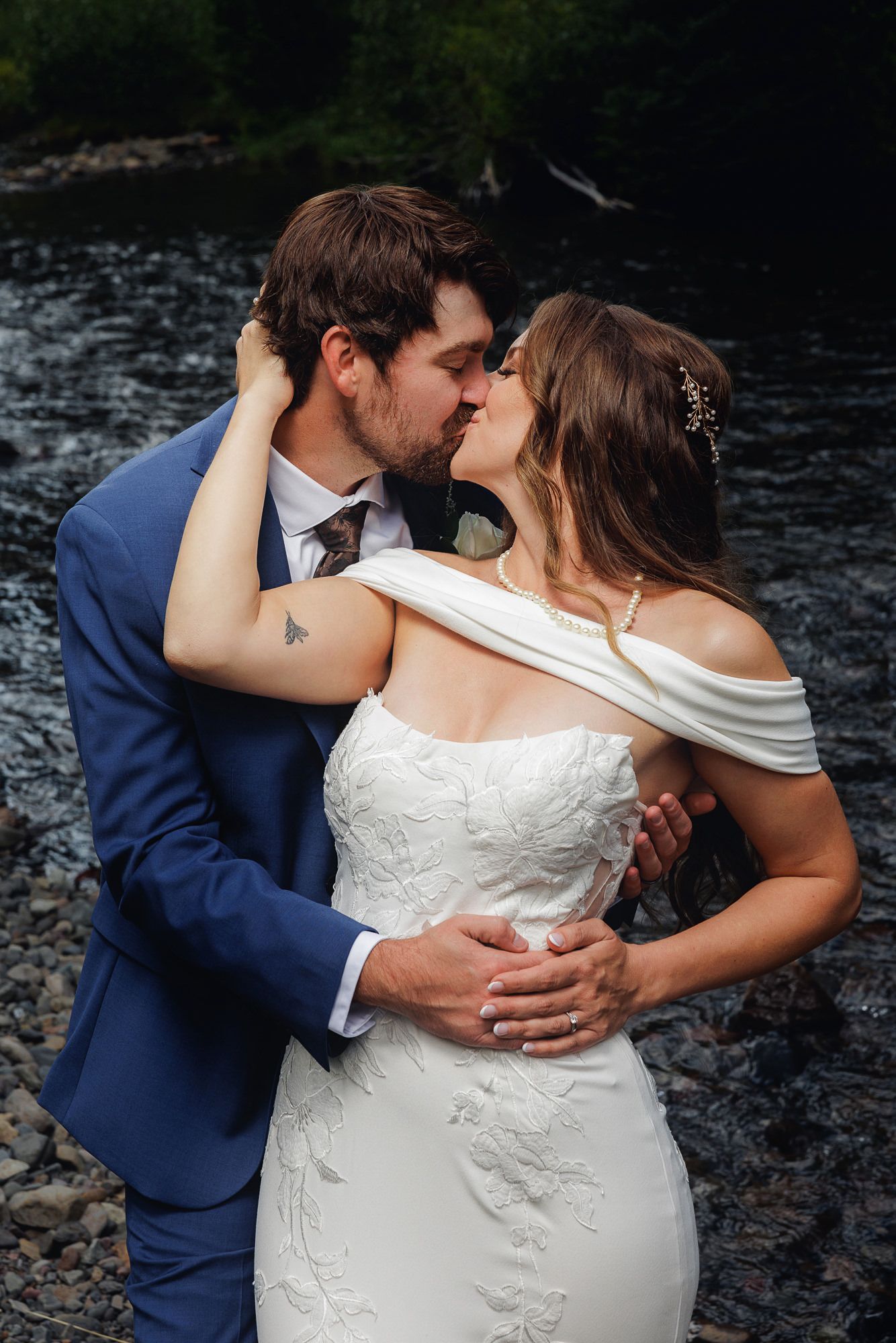 A romantic wedding couple embraces on a rocky shore in intimate detail shots showing tender moments between them.
