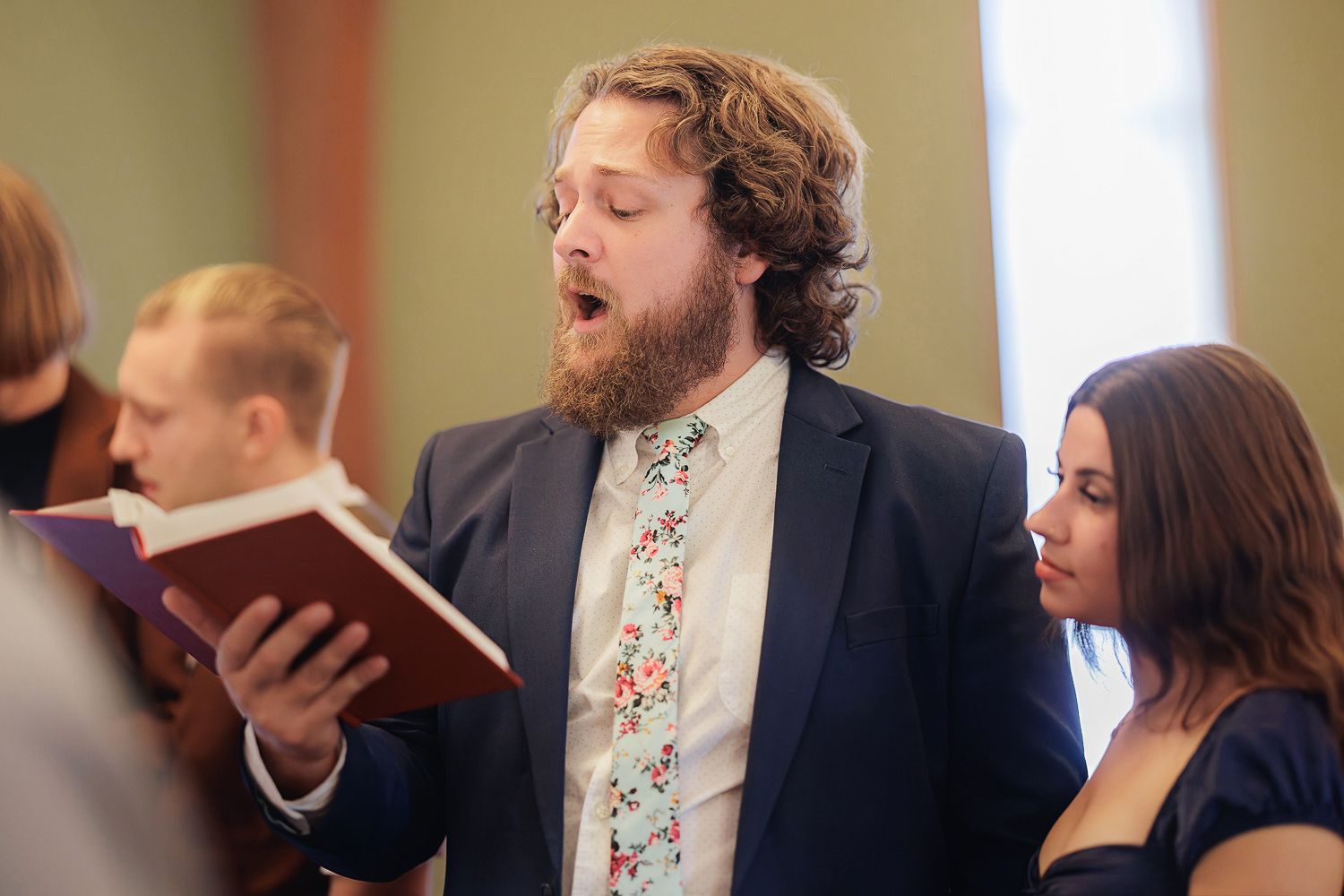A series of five photos showing people singing together during a musical performance.