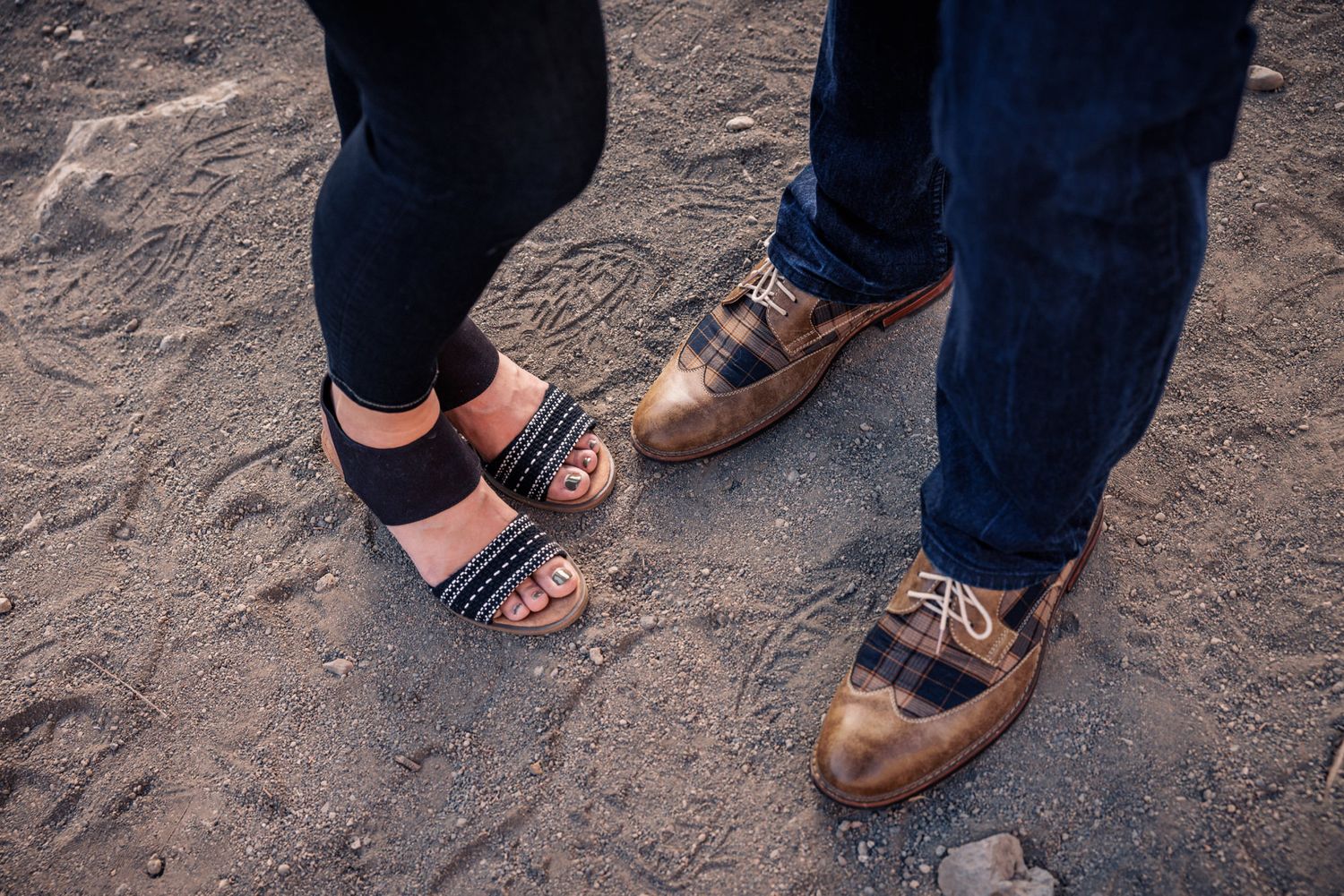Close-up sequence of feet in brown leather shoes and sandals walking on a dirt path.