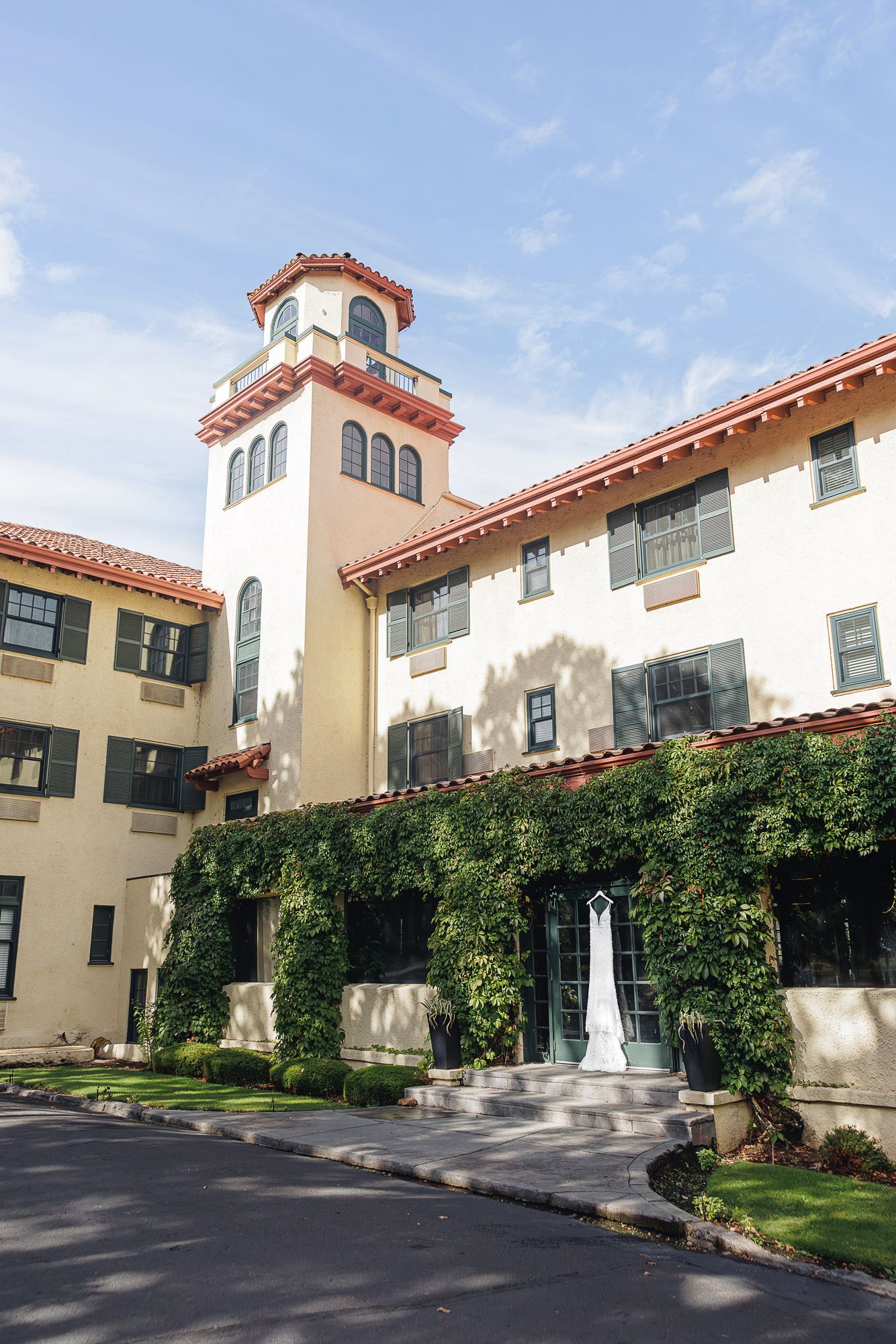 Spanish-style apartment buildings with terracotta roofs and cream stucco walls surrounded by manicured lawns and climbing vines.