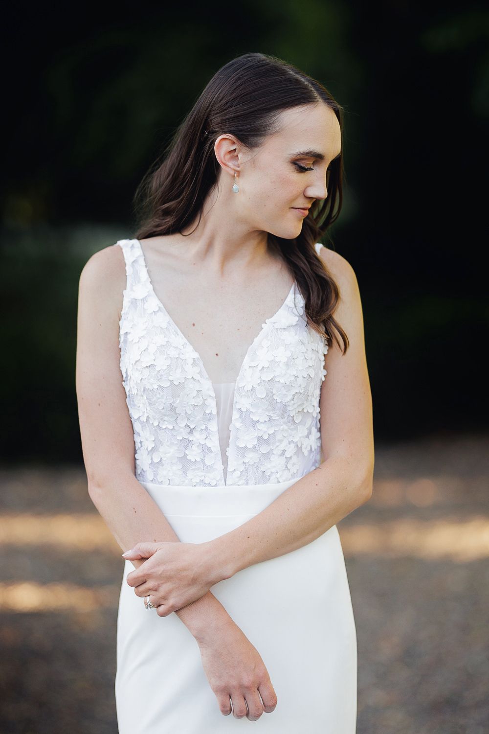 A series of four close-up photos showing details of a white lace wedding dress against a dark outdoor background.