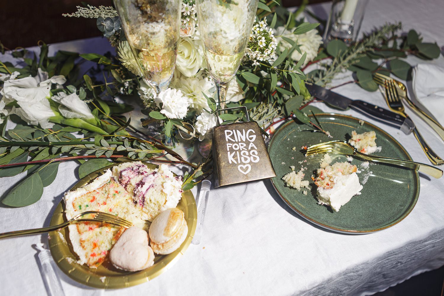 Decorative floral arrangements with eucalyptus leaves and white flowers displayed on a gray surface.