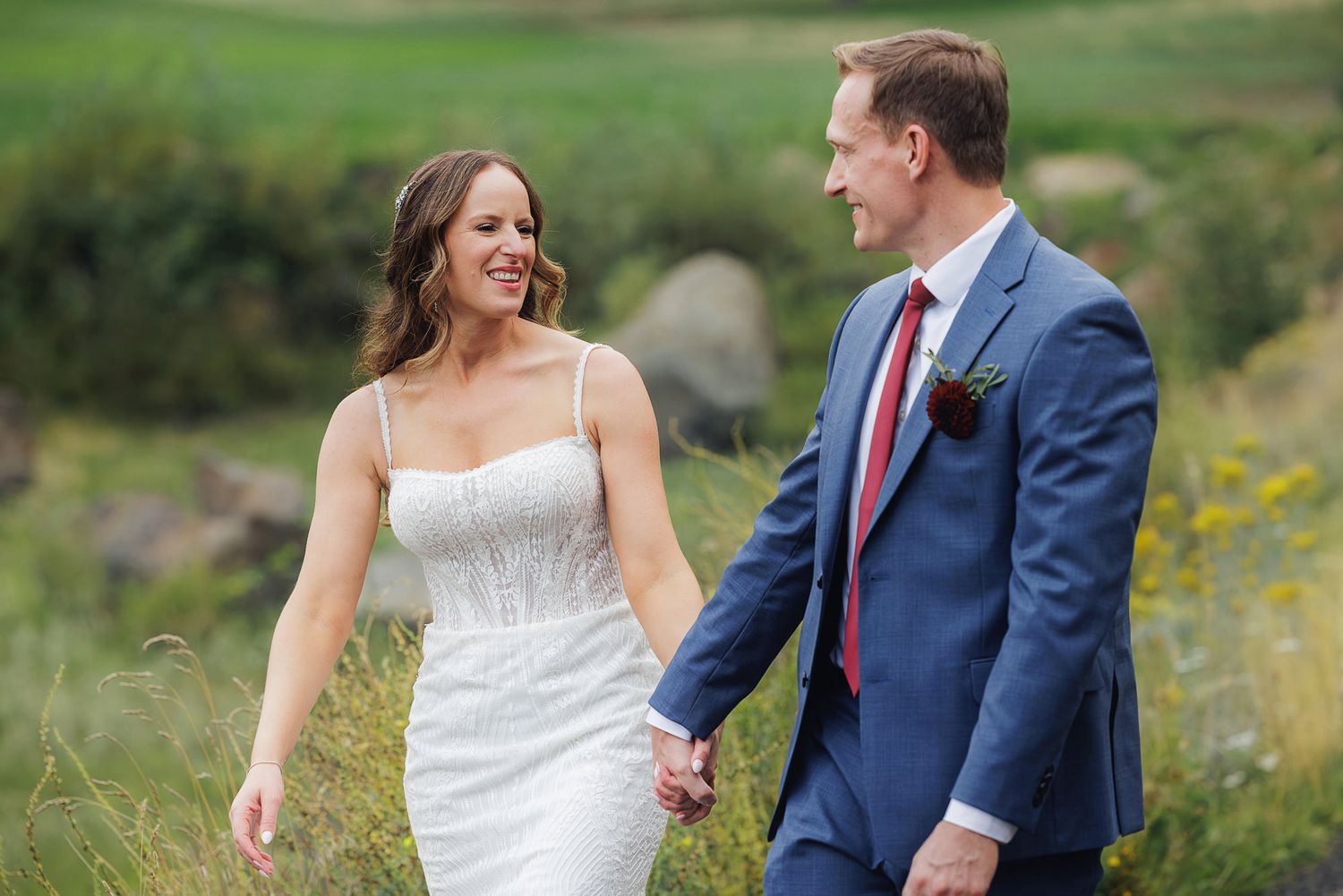 A couple shares joyful moments in a field of wildflowers during their wedding photoshoot.