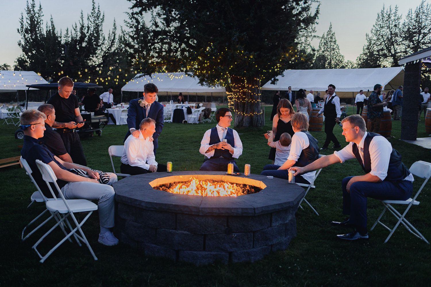 People gather around an outdoor fire pit at dusk for a relaxing social gathering and conversation.