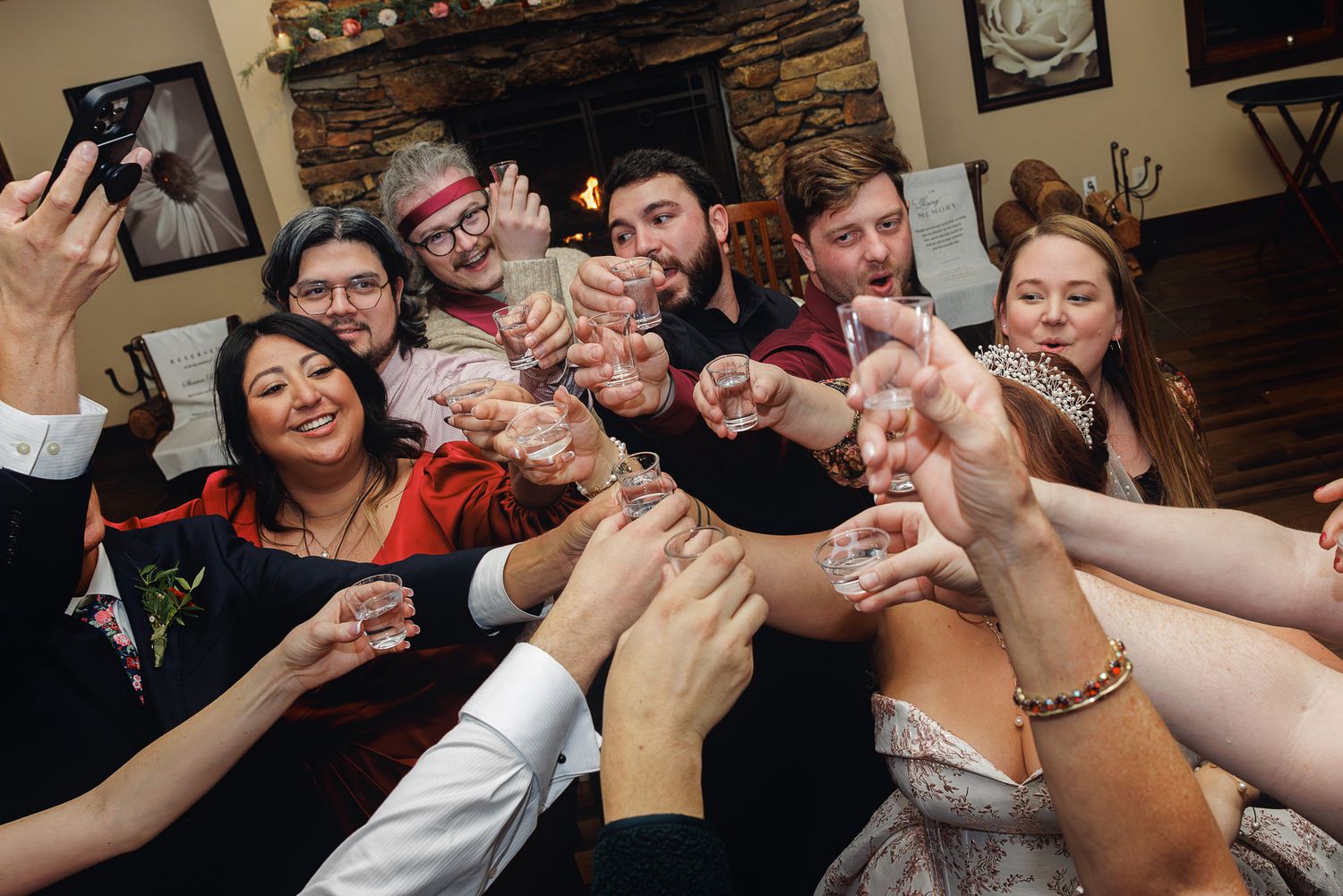A group of people raise their glasses together in a celebratory toast at a social gathering.