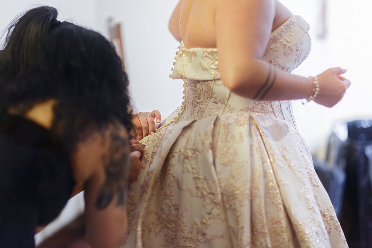 Close-up details of an ornate cream-colored lace wedding dress with intricate beading and embellishments.