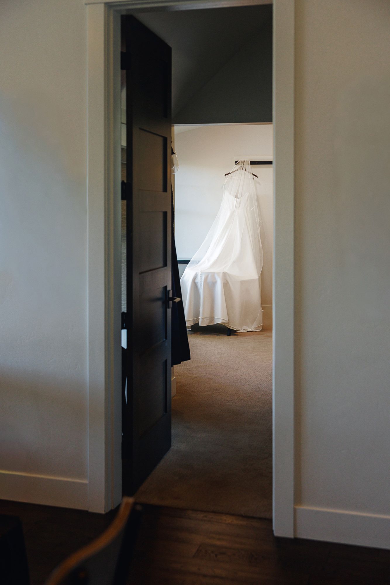 A series of dark doorways leading into a dimly lit hallway with white walls and hardwood floors.