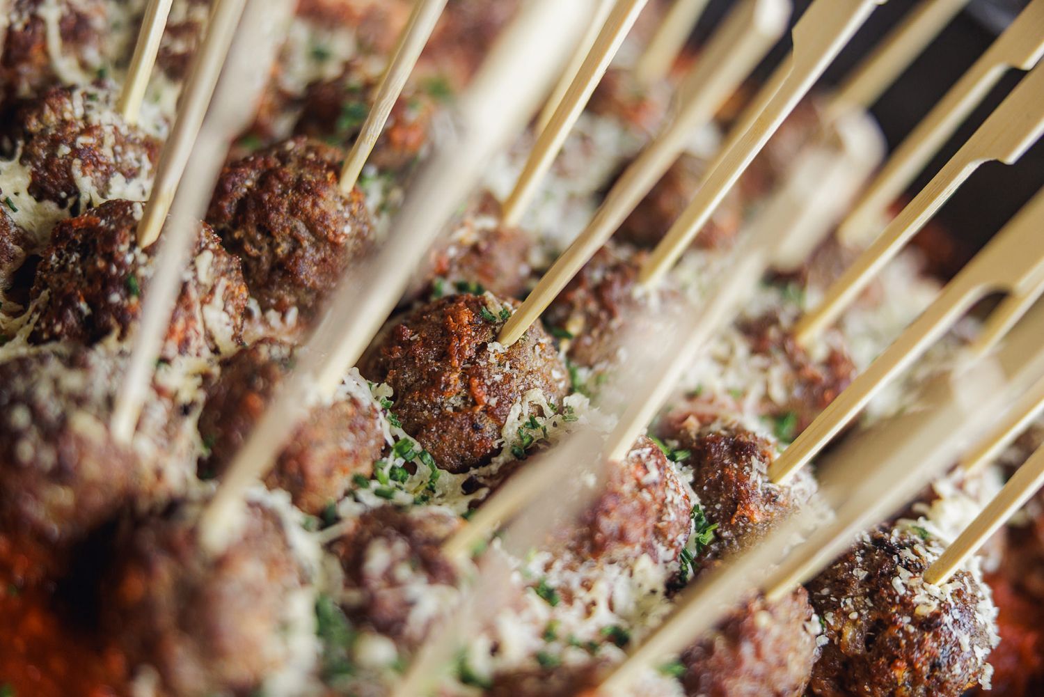 Juicy lamb chops on a grill being seasoned with herbs and spices for a delicious Mediterranean meal.