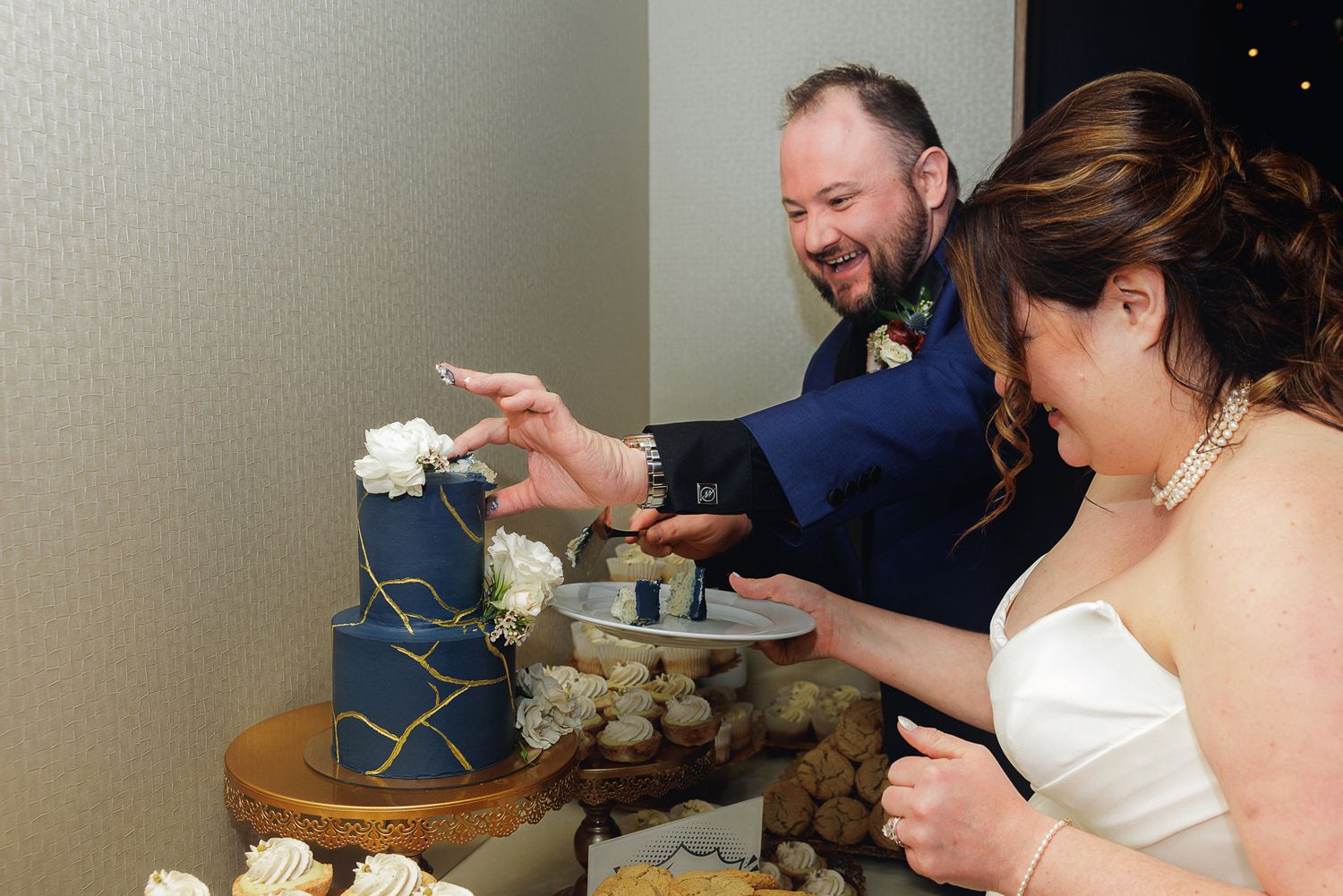A series of photos showing someone cutting into a white wedding cake at a reception celebration.
