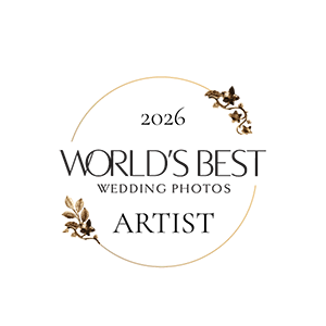 2026 World's Best Wedding Photos Artist badge, a prestigious award logo with gold floral accents and elegant typography.