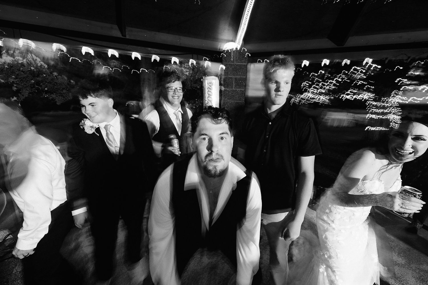 A vintage black and white distorted photo showing people in a bowling alley with bowling pin racks visible in background.