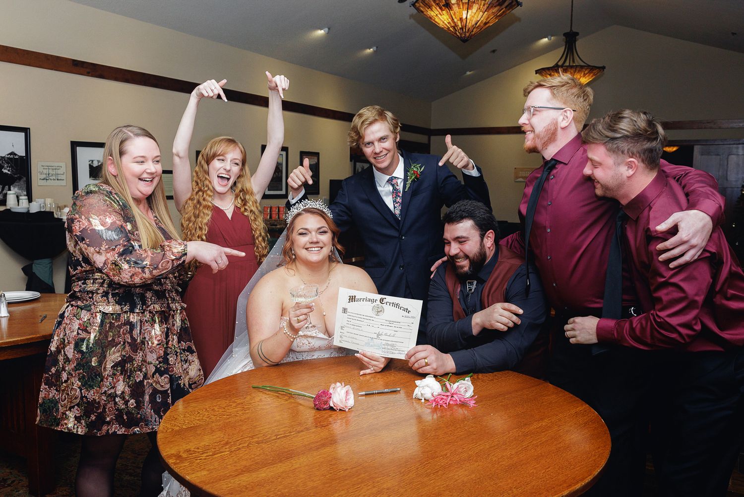 Group of people gathered around a table at a celebration event in an indoor venue.