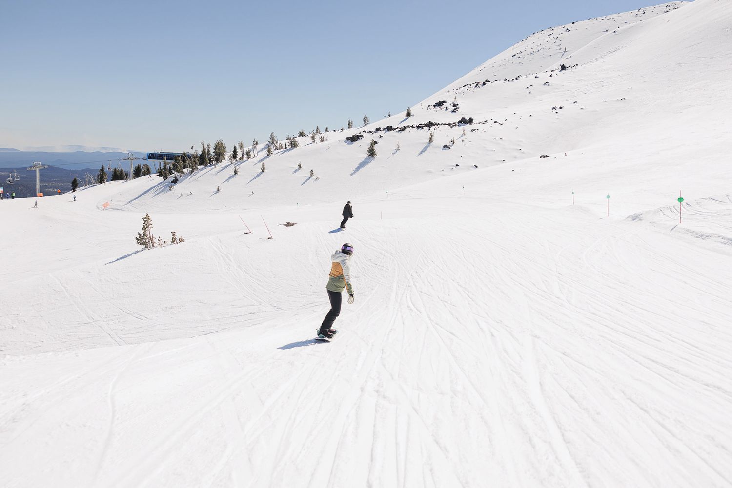 A person skiing down a snowy slope on a sunny day in the mountains.