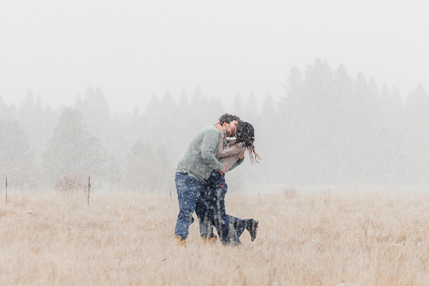 A photographer takes photos in a foggy field on a misty morning.