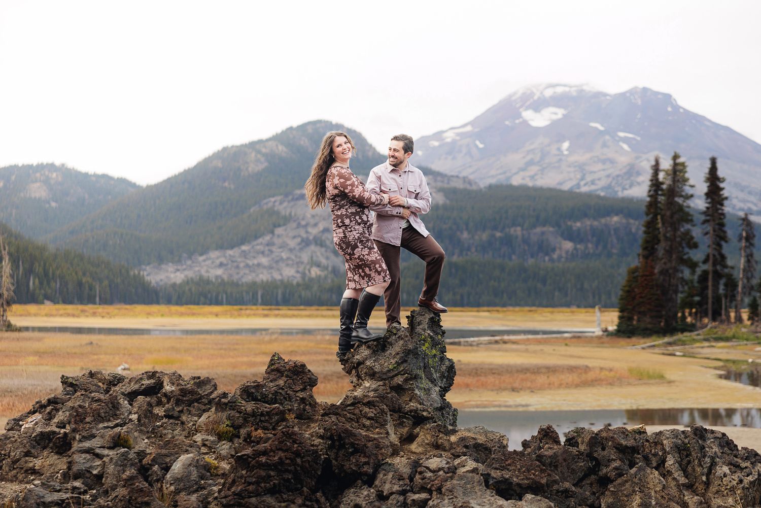 Hikers explore scenic mountain trails with snow-capped peaks and evergreen forests in the rugged wilderness landscape.