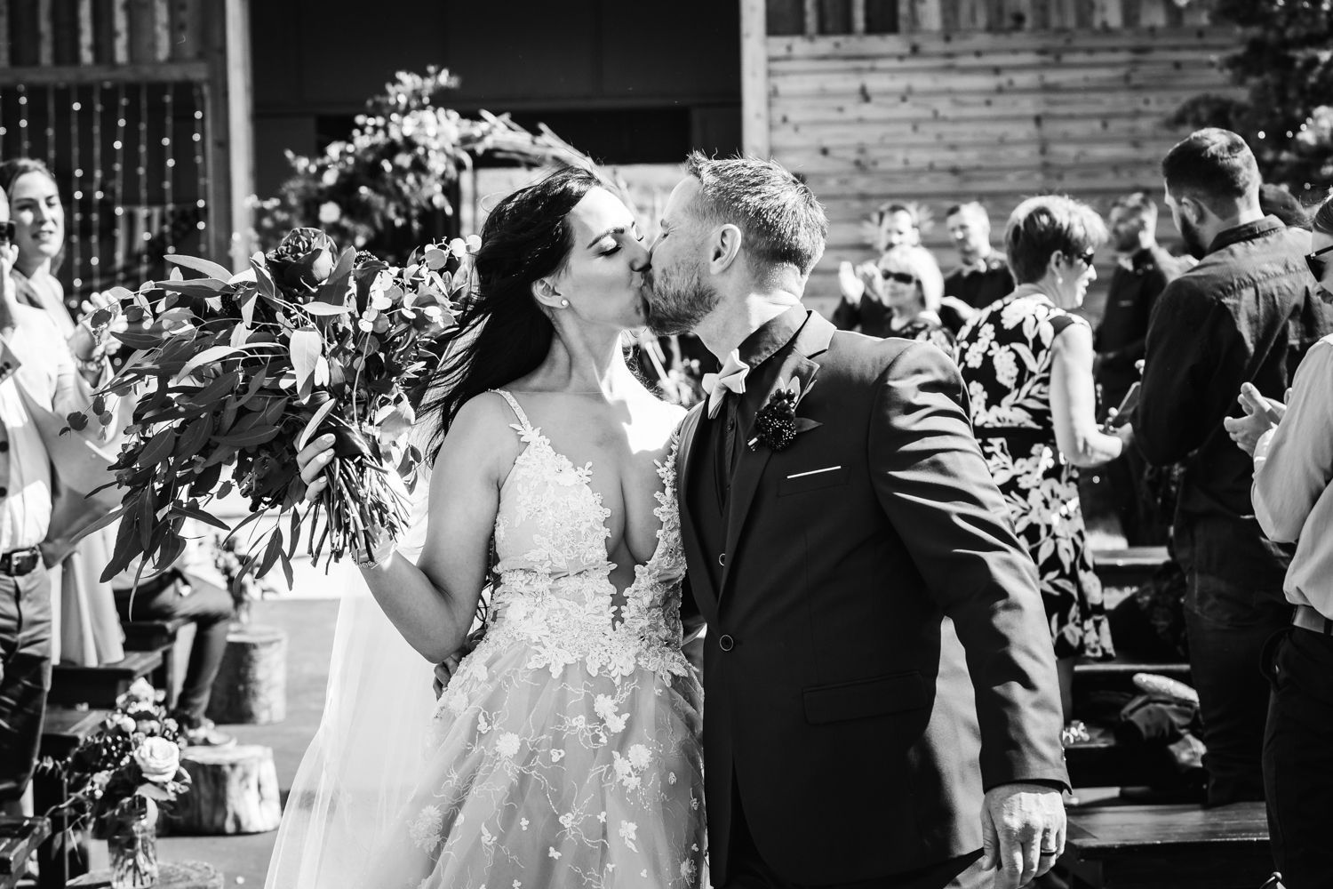 A joyful outdoor celebration moment with elegant floral decor and formal attire.