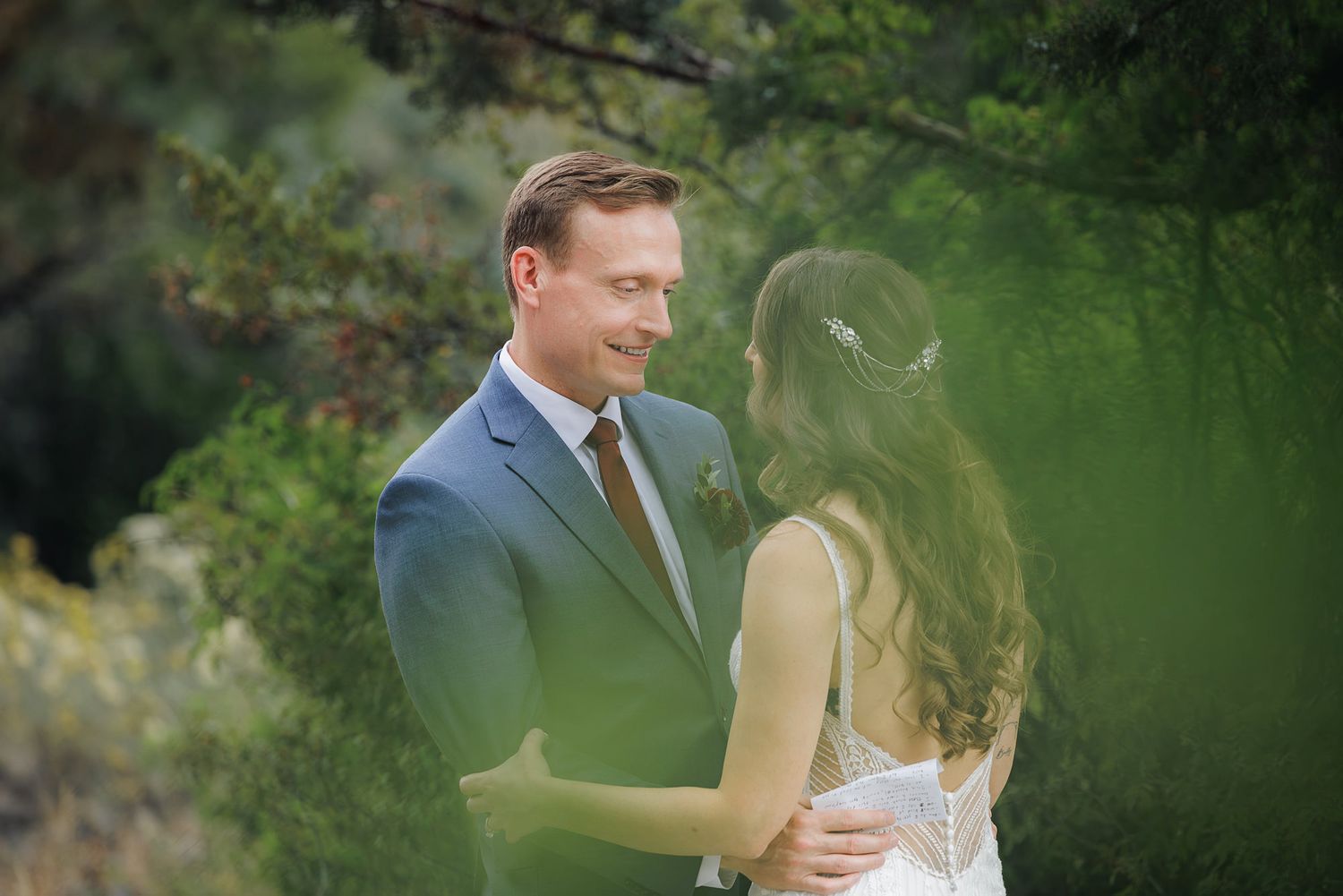 A couple shares intimate moments in a lush green garden setting during their romantic outdoor photo session.