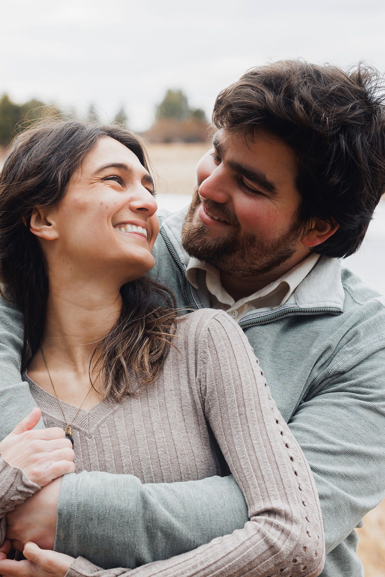 A couple in cozy sweaters sharing intimate moments and laughter in a series of romantic outdoor photos.