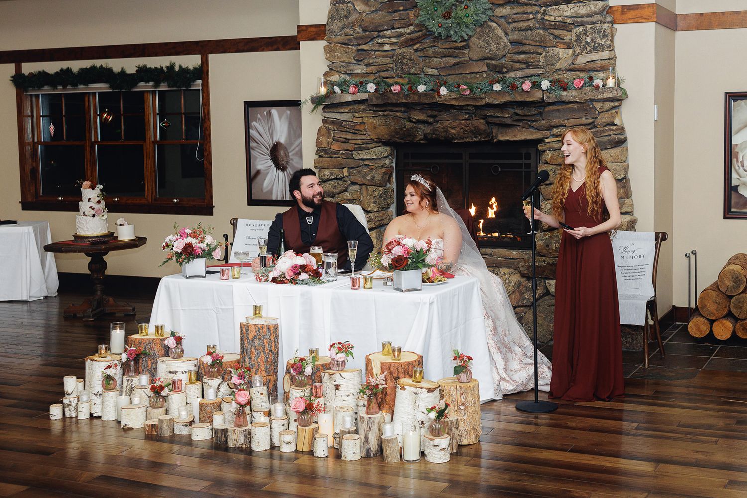 Wedding reception tables decorated with elegant candles and floral centerpieces in a rustic stone-walled venue.