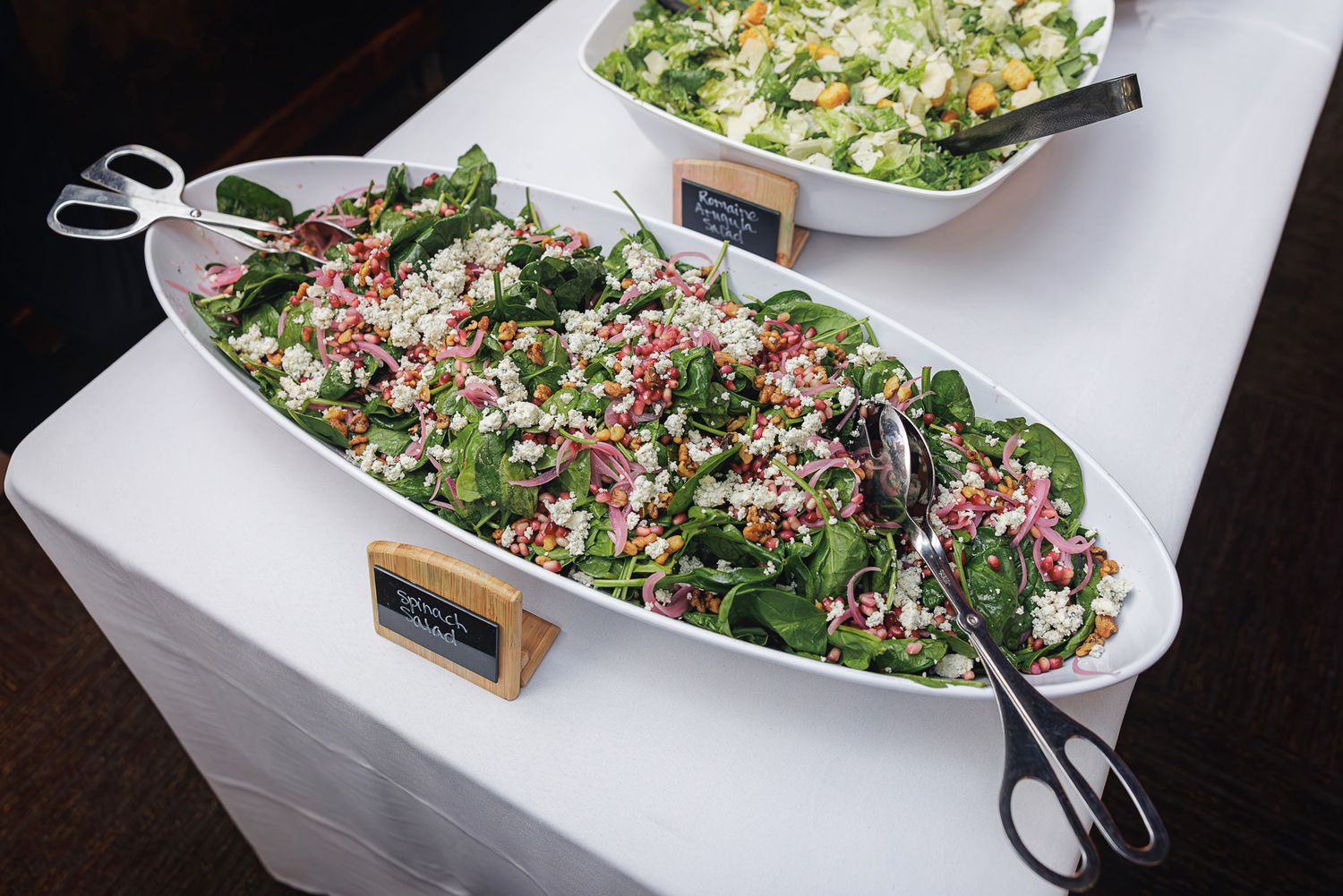 Fresh quinoa salad with mixed vegetables and herbs served in an elegant white boat-shaped serving dish.
