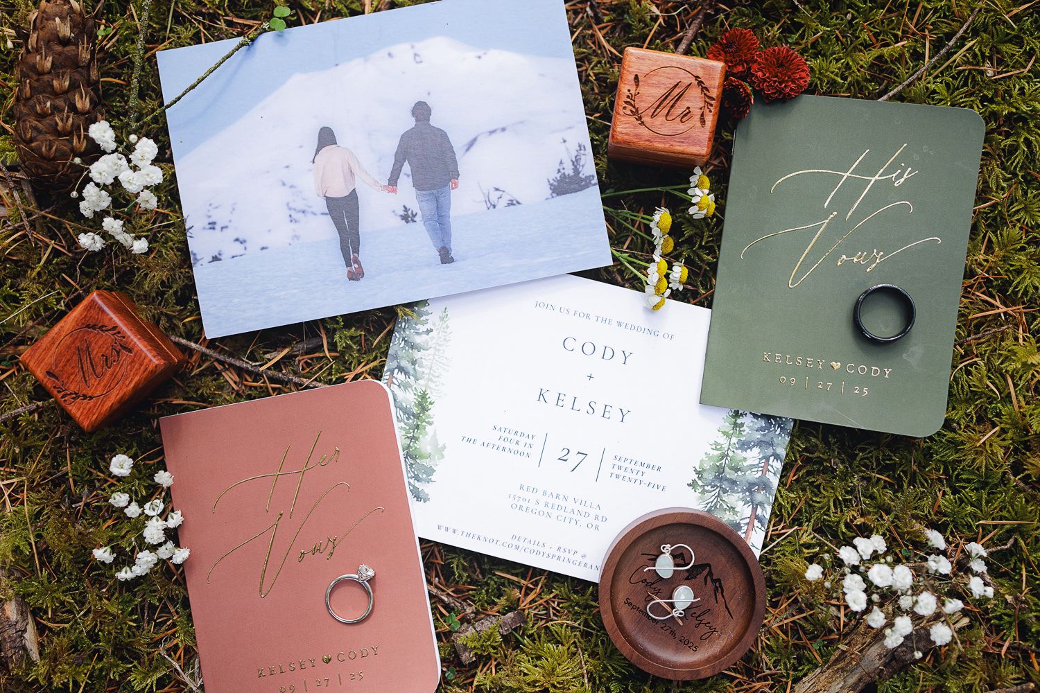 Flat lay of wedding stationery including save the dates, invitations, and envelopes in sage green and terracotta colors.