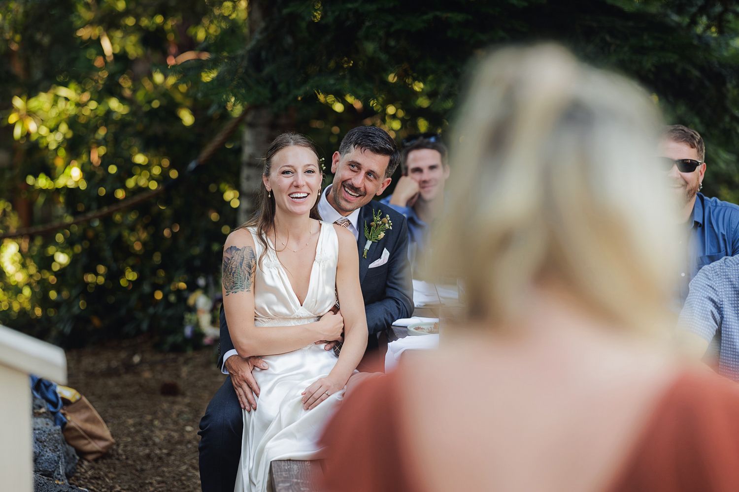 A wedding celebration set outdoors with natural lighting and joyful moments being captured in a garden setting.