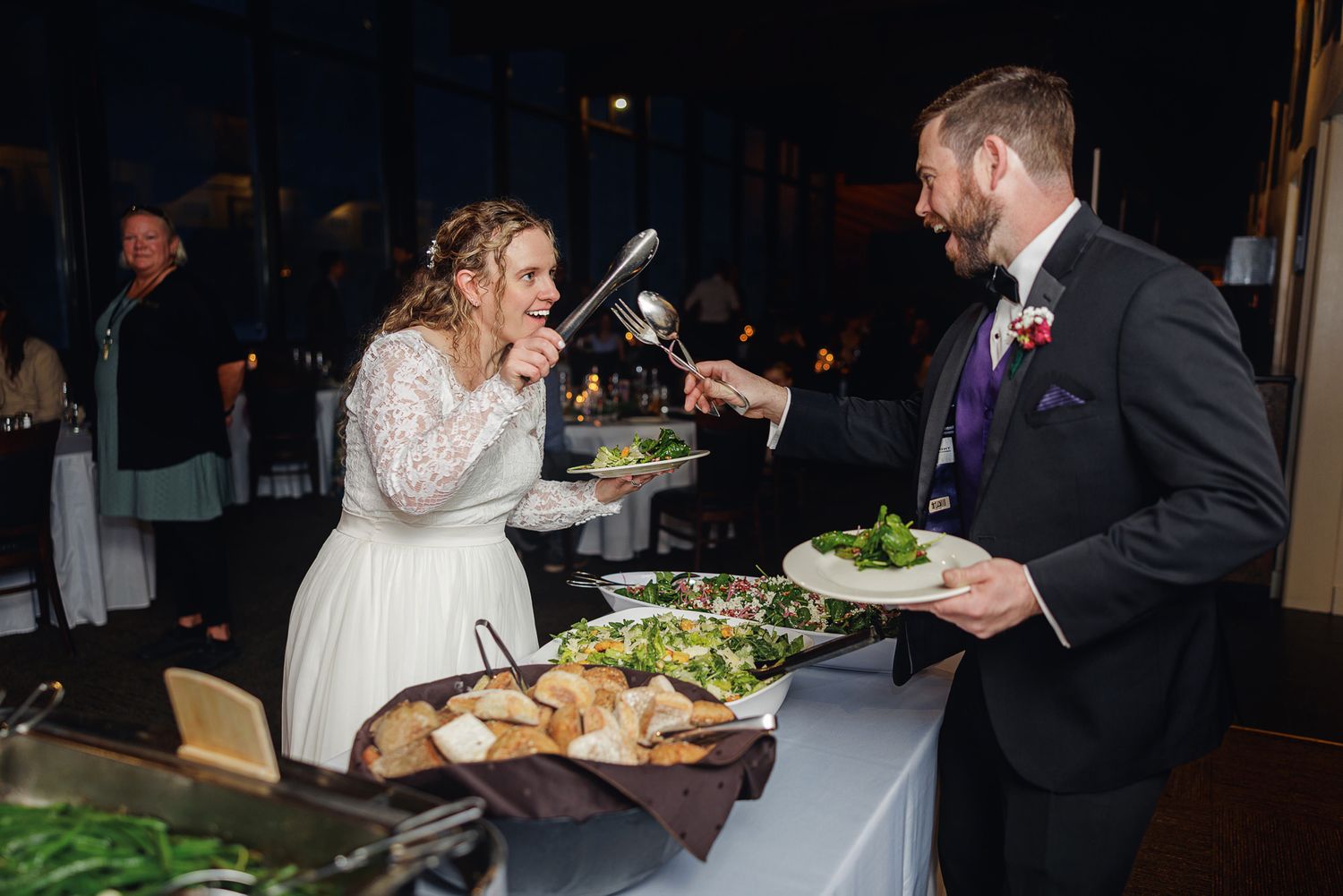 Wedding reception guests enjoy a buffet-style dinner service at an elegant indoor venue.