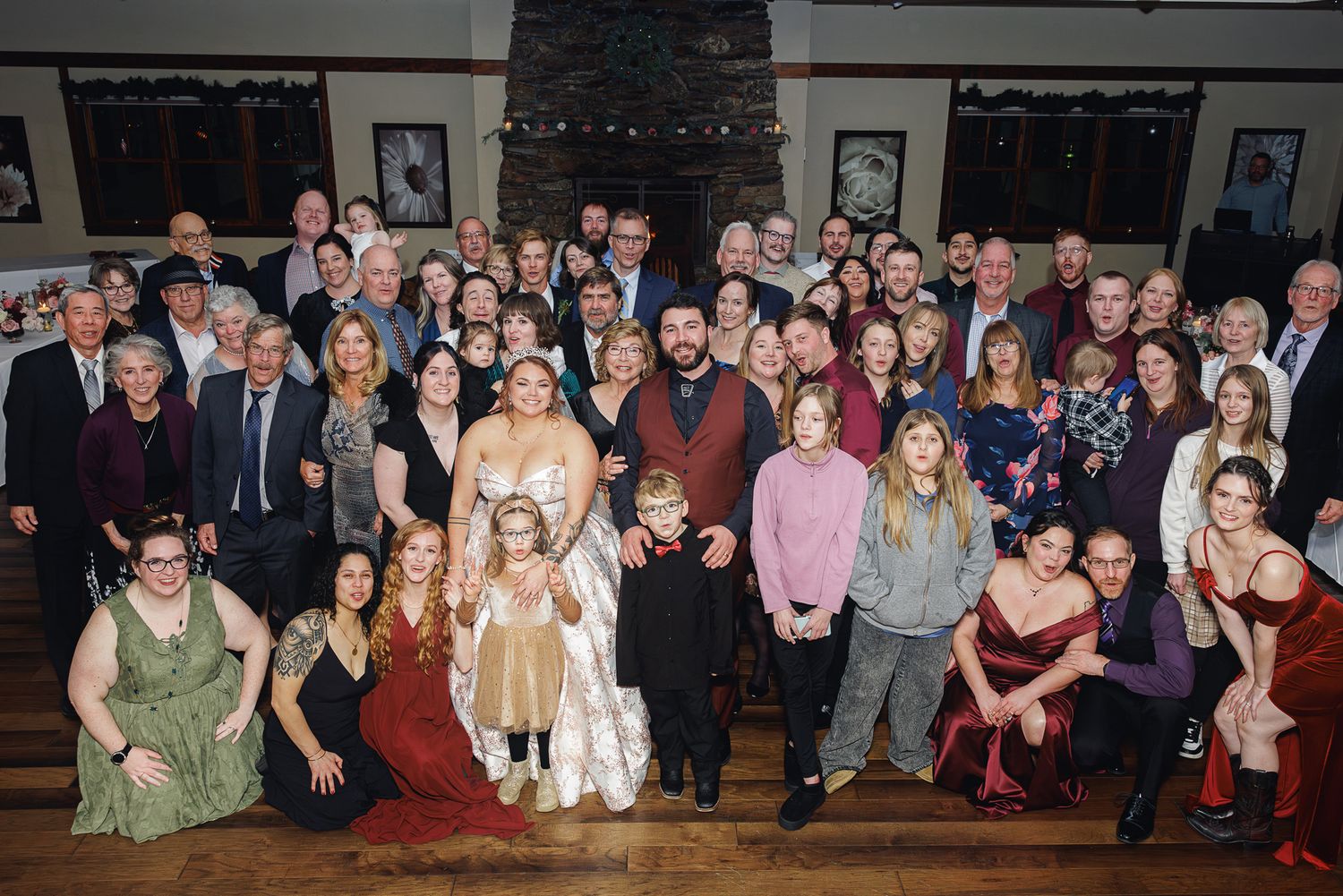 Large group photo of wedding guests posing together at reception venue.