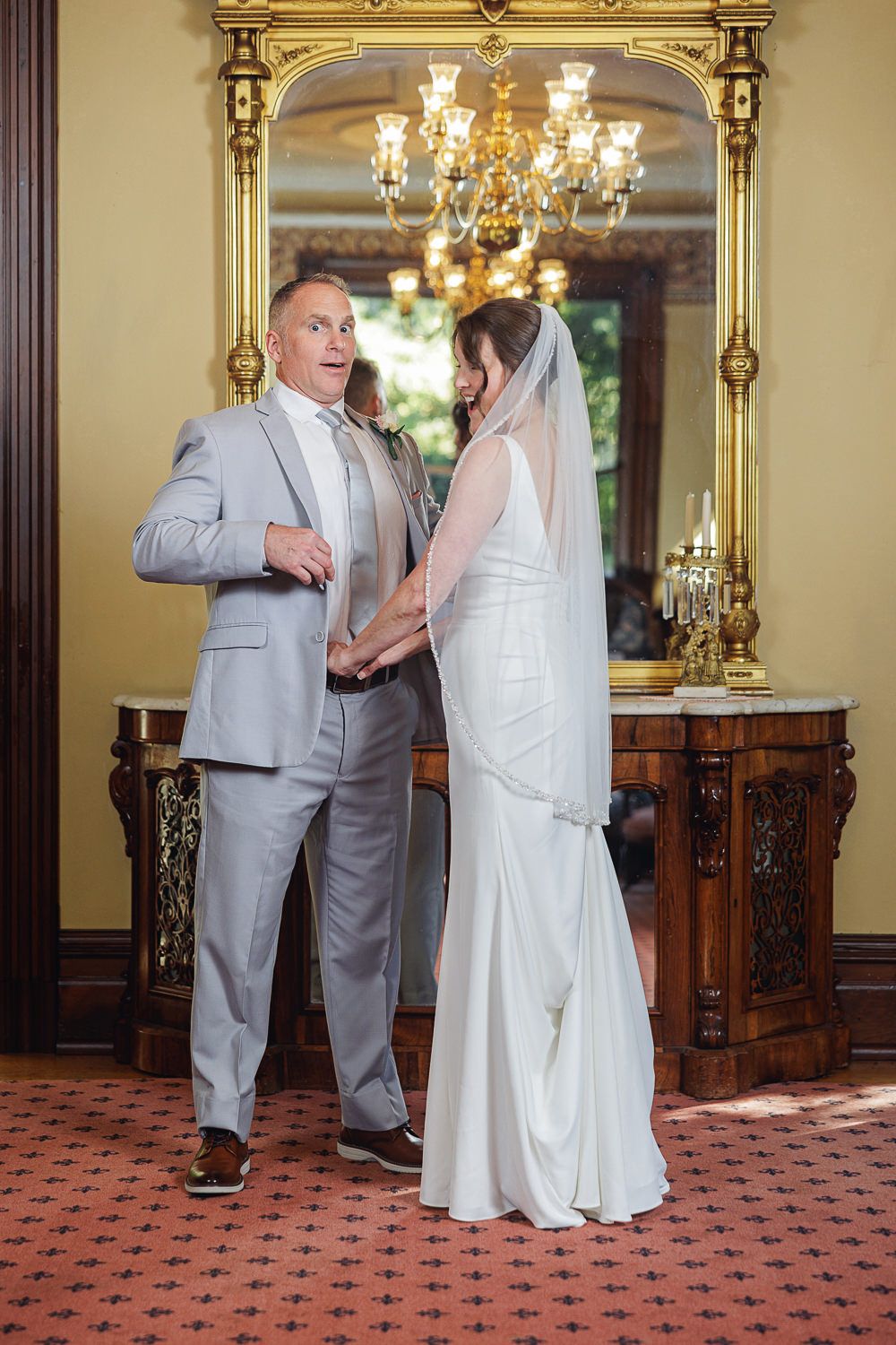 Dancing sequence shows special moment at wedding reception in ornate room with red carpet.
