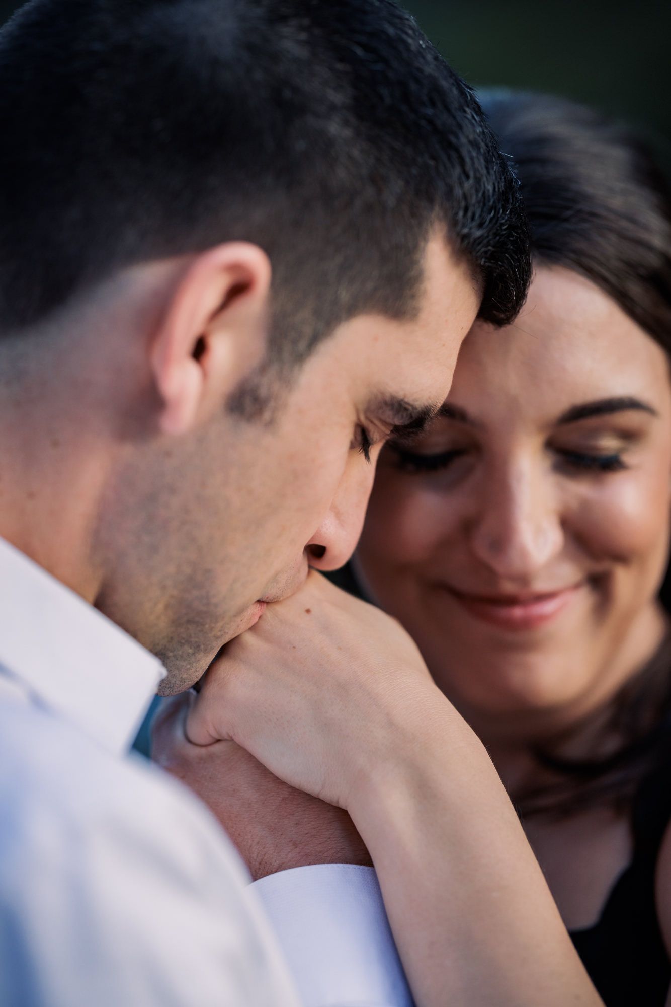 A tender romantic moment between a couple as they share an intimate gesture outdoors.