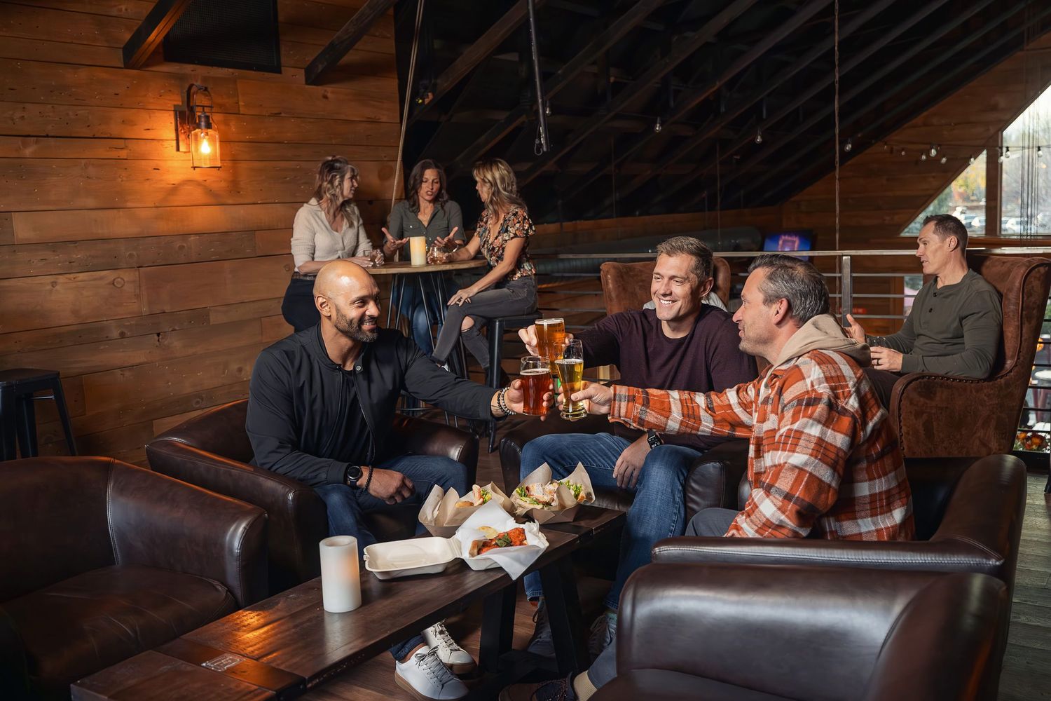 Cozy rustic restaurant interior with leather seating and wooden walls.