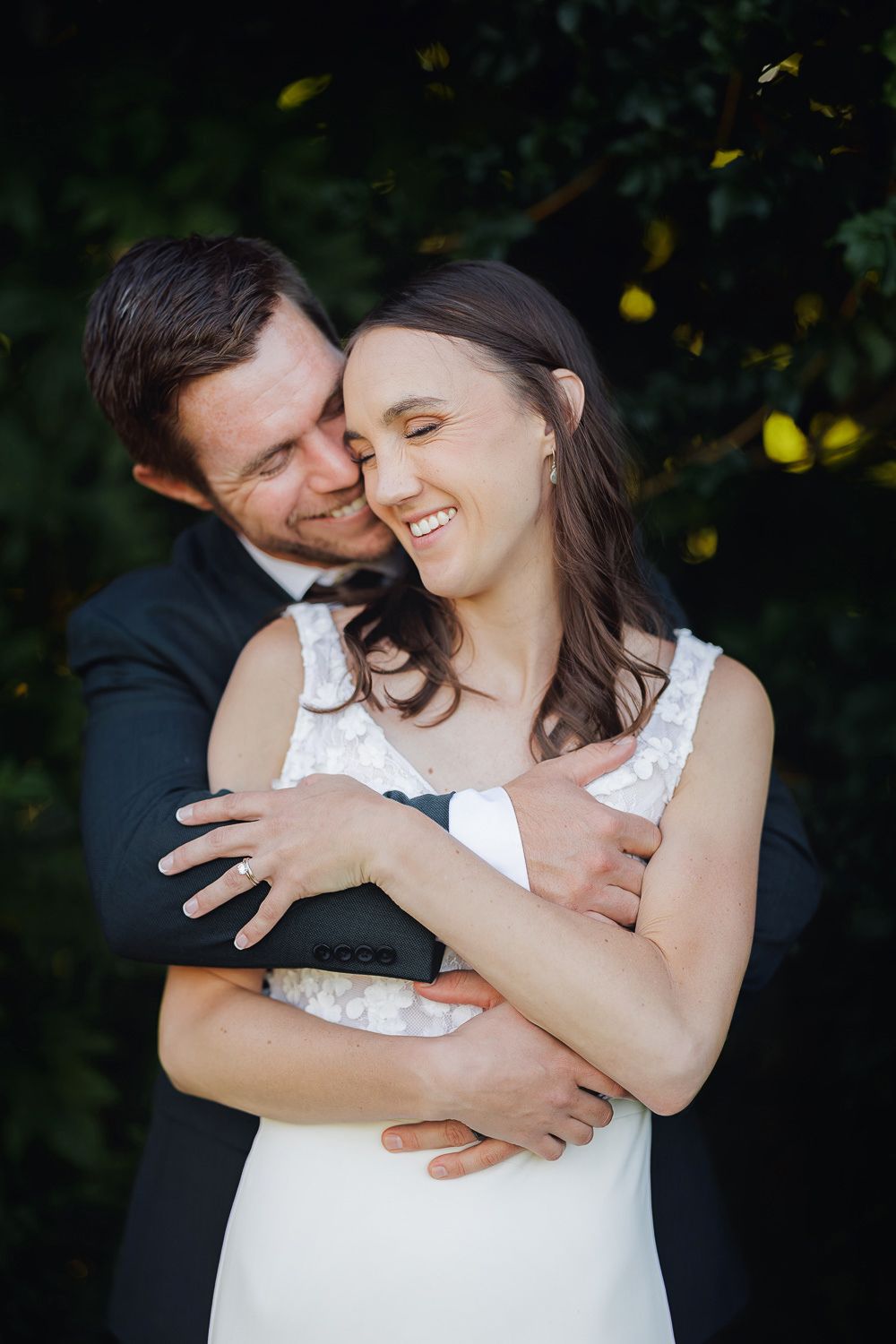 A couple shares a joyful embrace outdoors with laughter and natural lighting in a romantic photoshoot sequence.