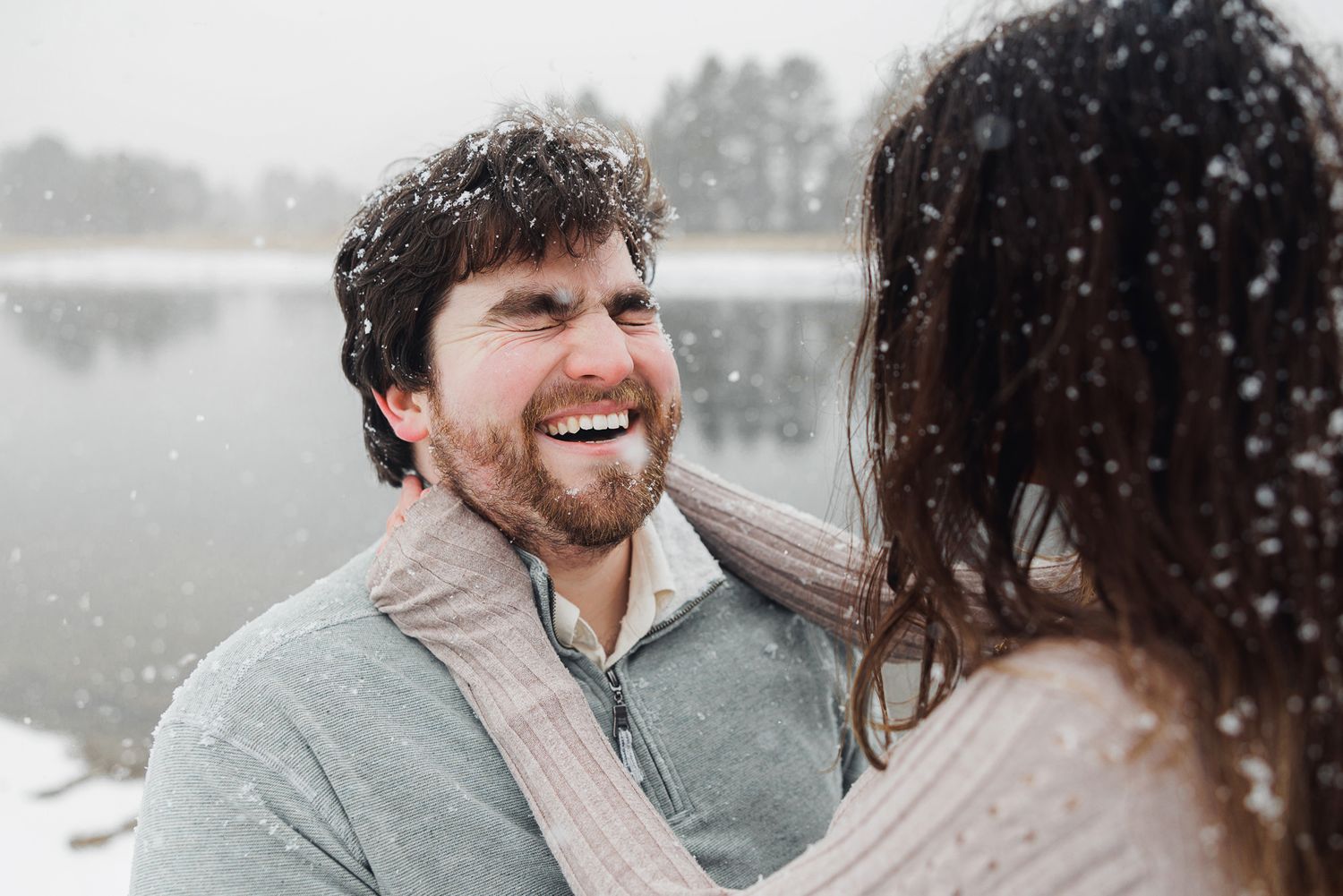 A couple shares a romantic moment in the snow during a winter photo session.