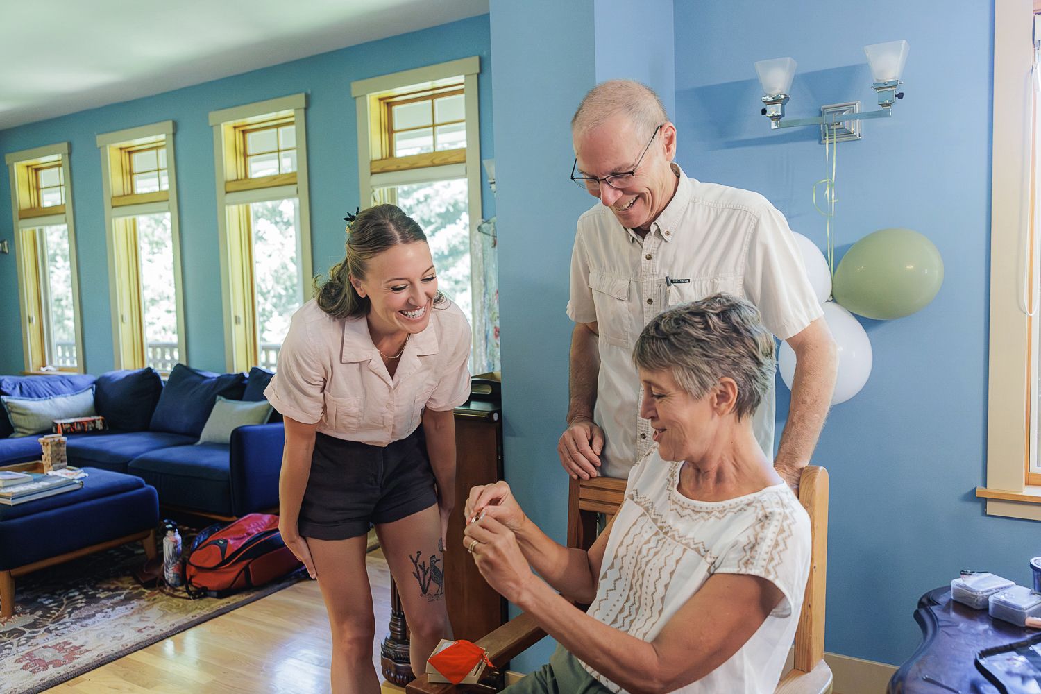 Healthcare professionals assist and encourage a patient during a physical therapy session in a bright blue rehabilitation room.