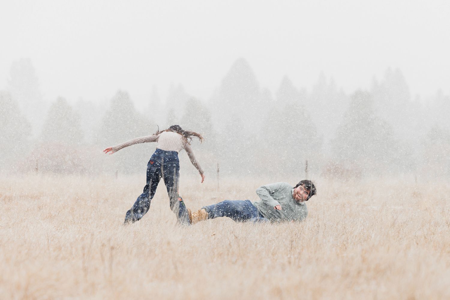 A person lies down in a golden wheat field on a misty morning creating a peaceful and serene scene.
