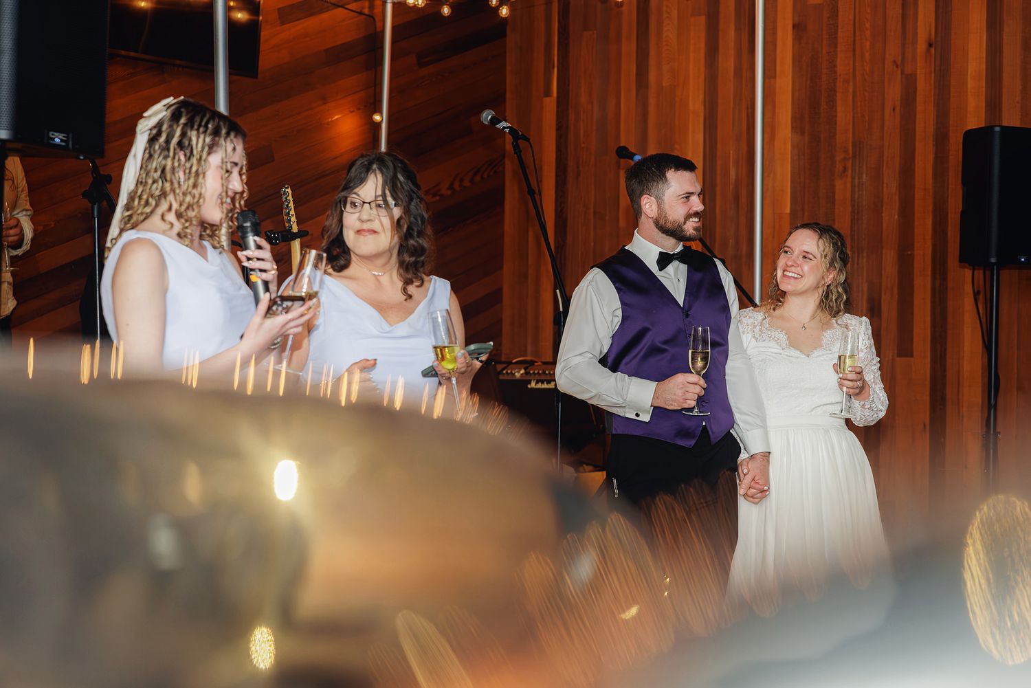 Elegant wedding celebration in a rustic wood-paneled venue with ambient lighting.
