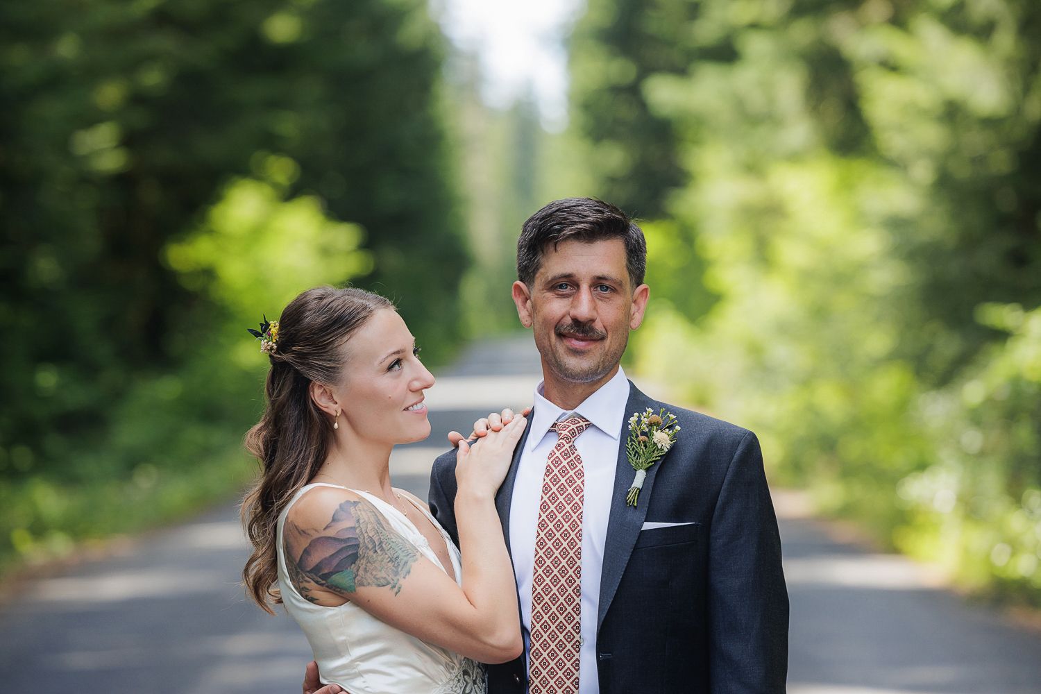 A couple shares romantic moments in an outdoor garden setting during their wedding celebration.