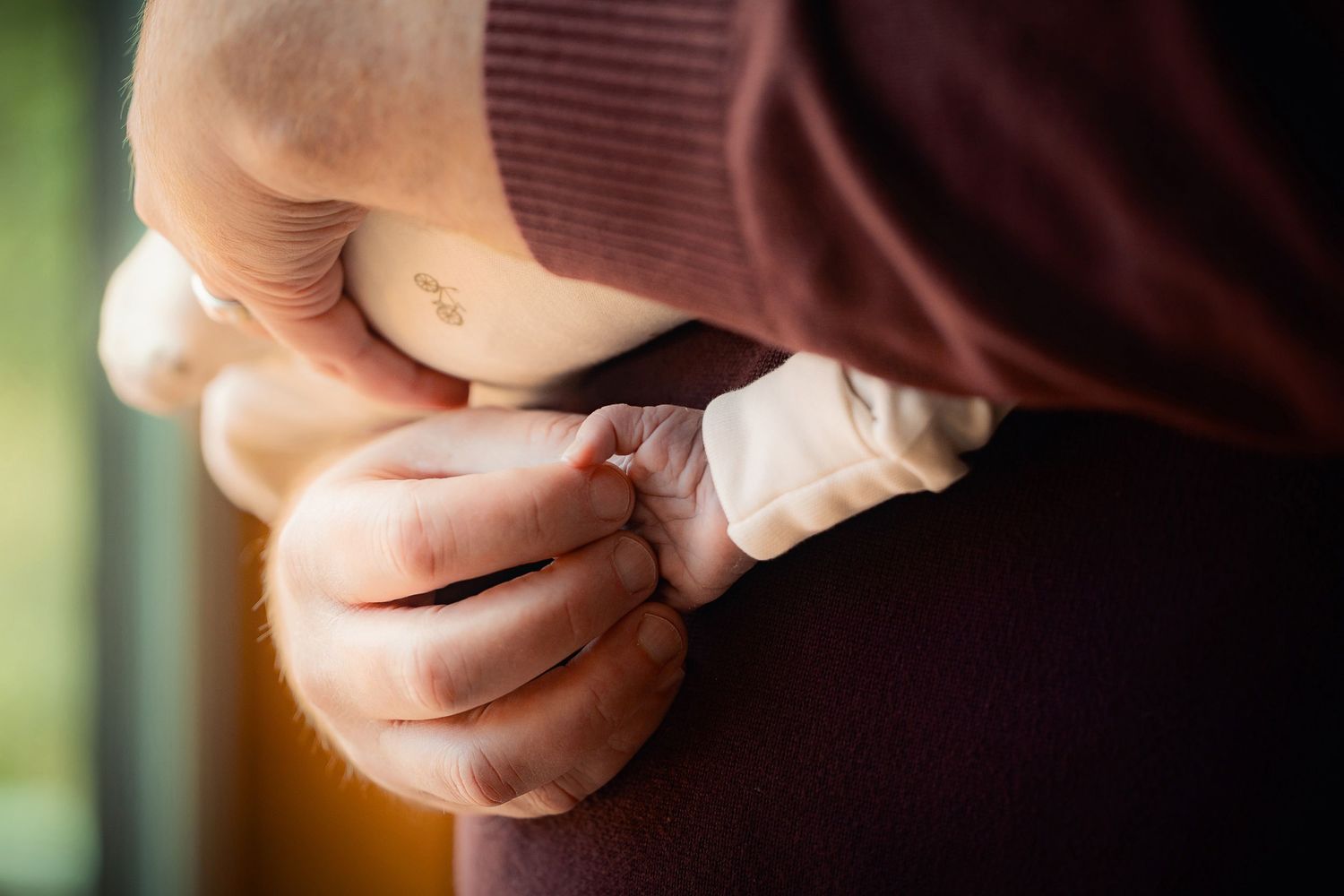 Close-up view of hands carefully wrapping a bandage around a person's finger in warm lighting.