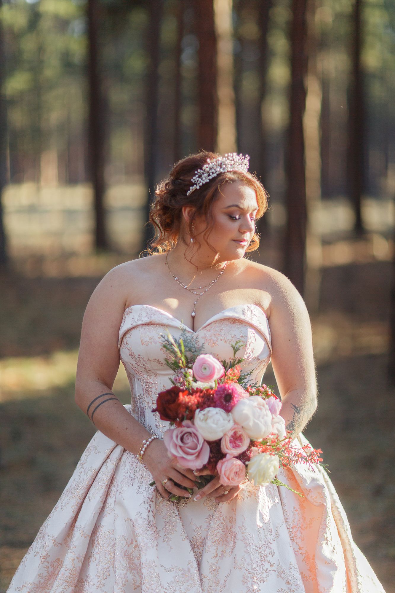 Beautiful wedding dress details and floral bouquet photographed in a serene forest setting.