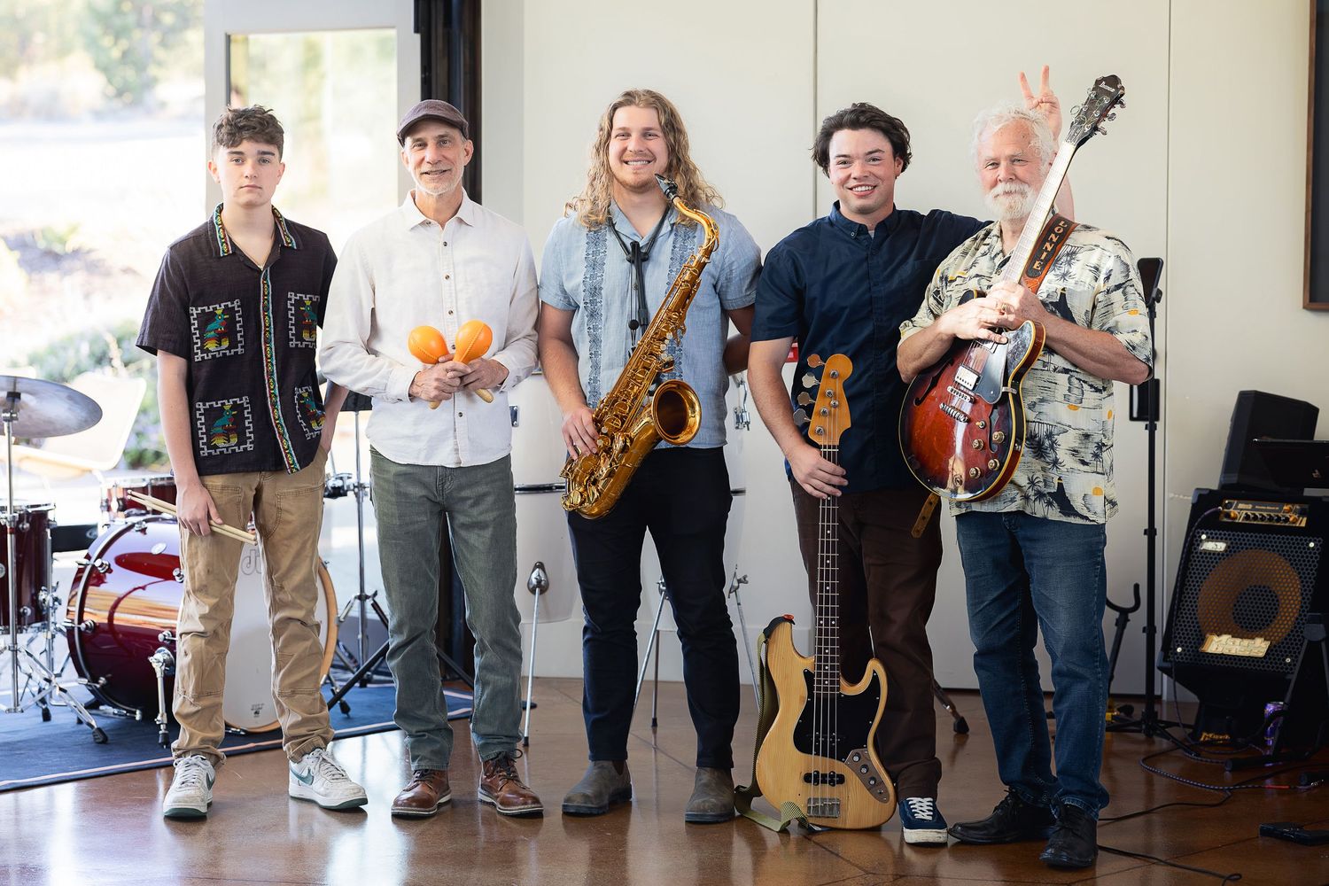 Musicians posing with their instruments in a studio space.
