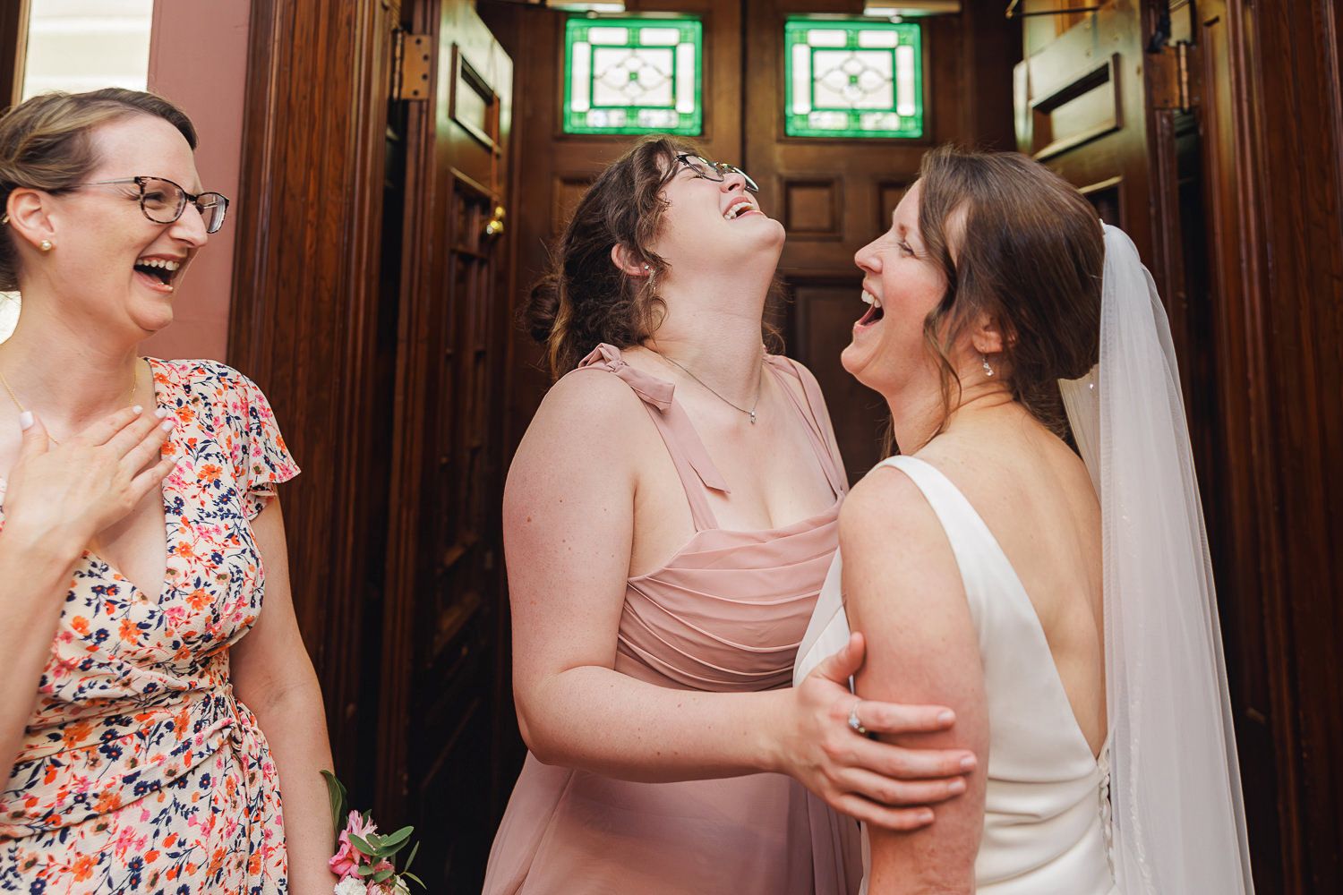 A series of candid moments showing people laughing and embracing in a warmly lit indoor venue with wooden decor.