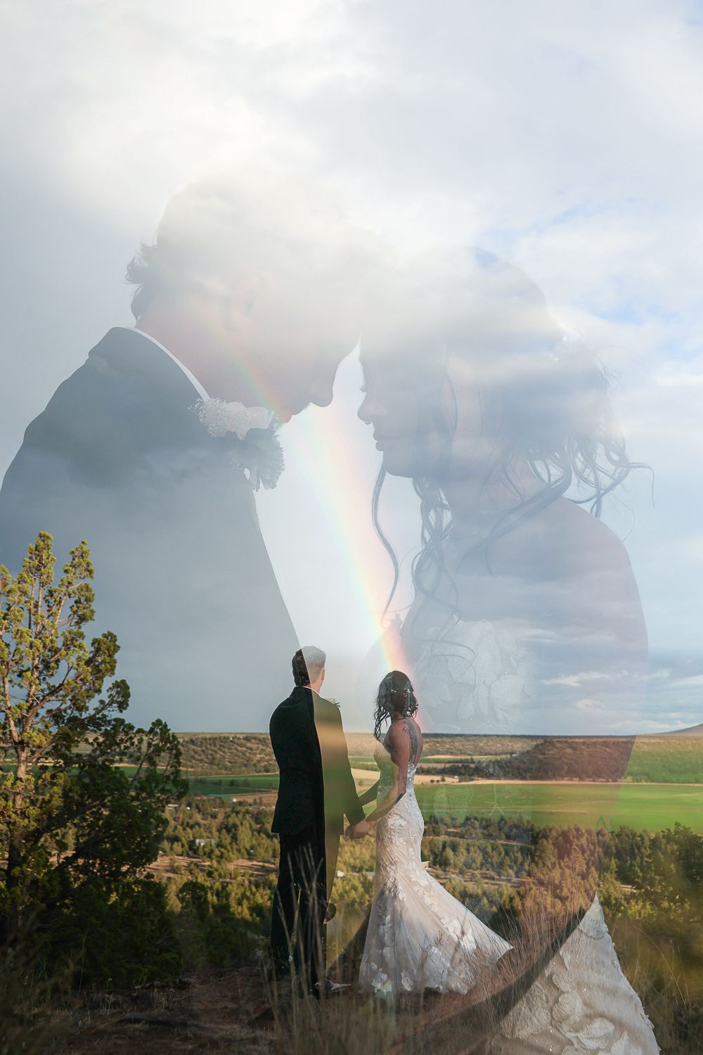 Double exposure wedding photograph shows couple silhouetted against scenic countryside landscape and cloudy sky.