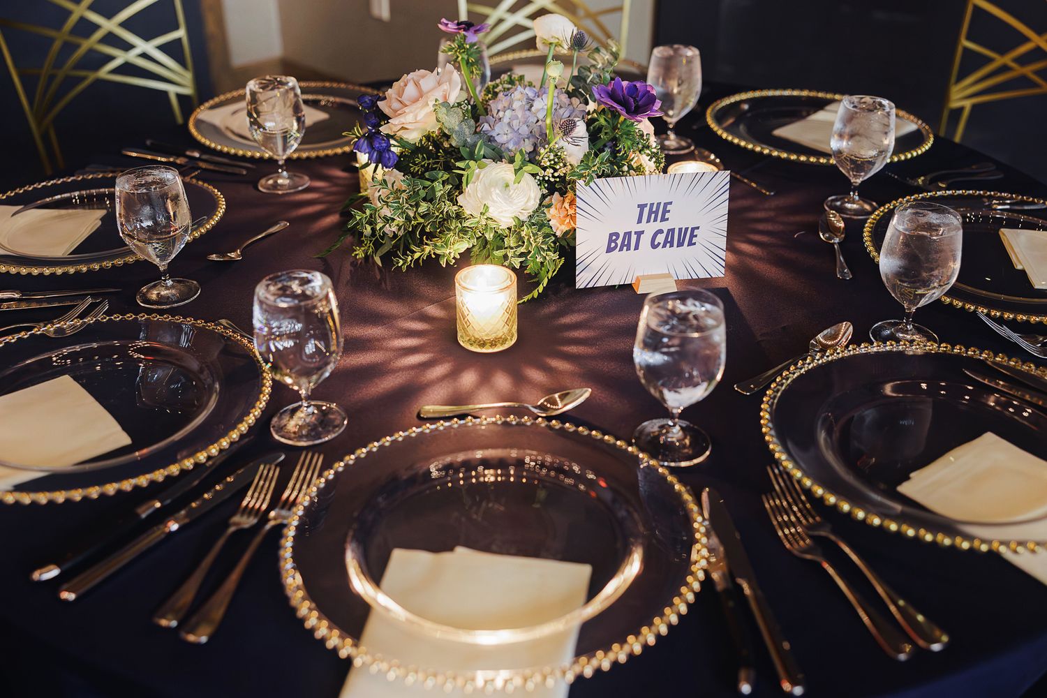 Elegant wedding reception table settings with gold beaded charger plates, crystal glassware, and soft candlelight.