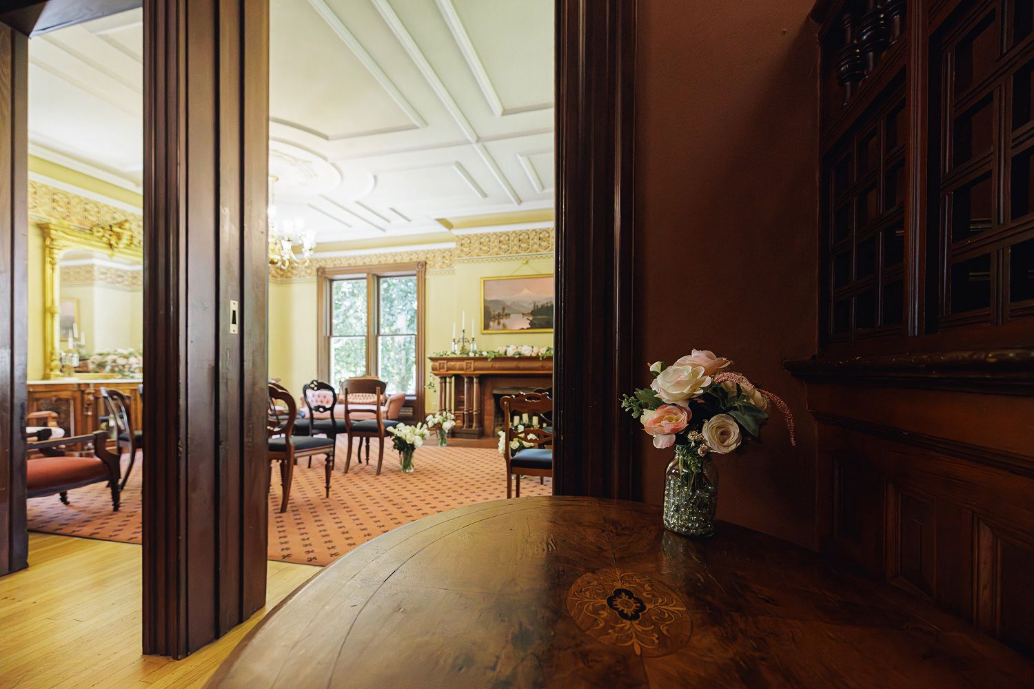 Elegant ballroom interior with grand chandeliers, ornate moldings, and luxurious carpeting spanning a panoramic view.