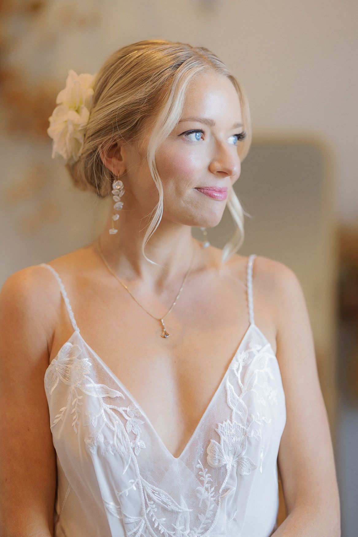 Elegant bridal portrait featuring delicate jewelry and lace details in soft natural light.